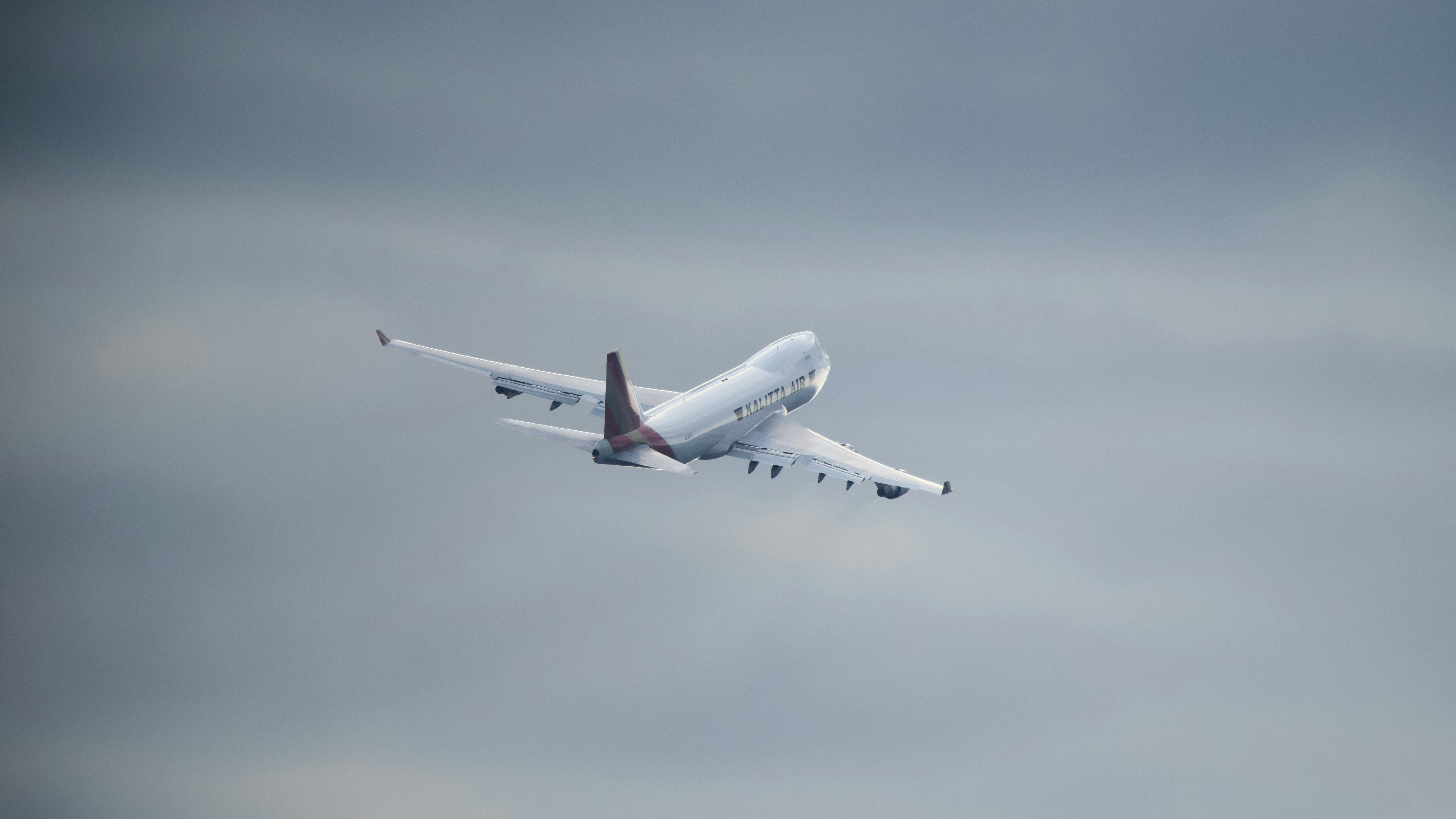 Airplane ascending into a cloudy sky