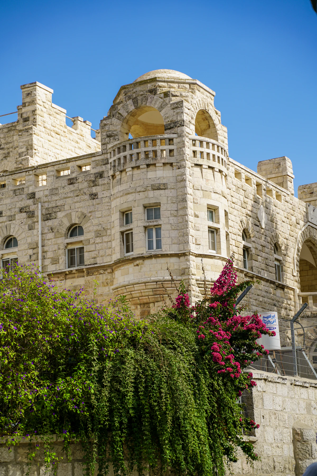 A Jerusalem stone house with arched windows and flowering vines