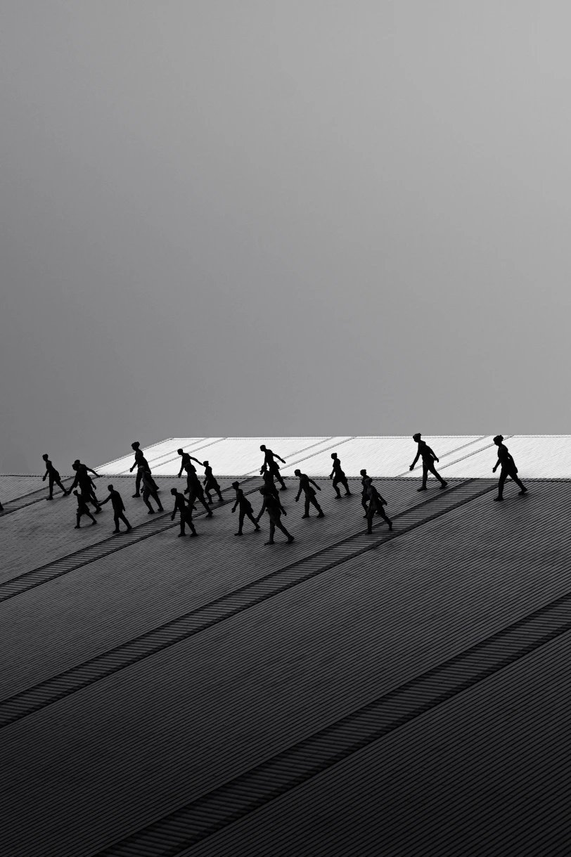 Silhouettes of people walking with long shadows