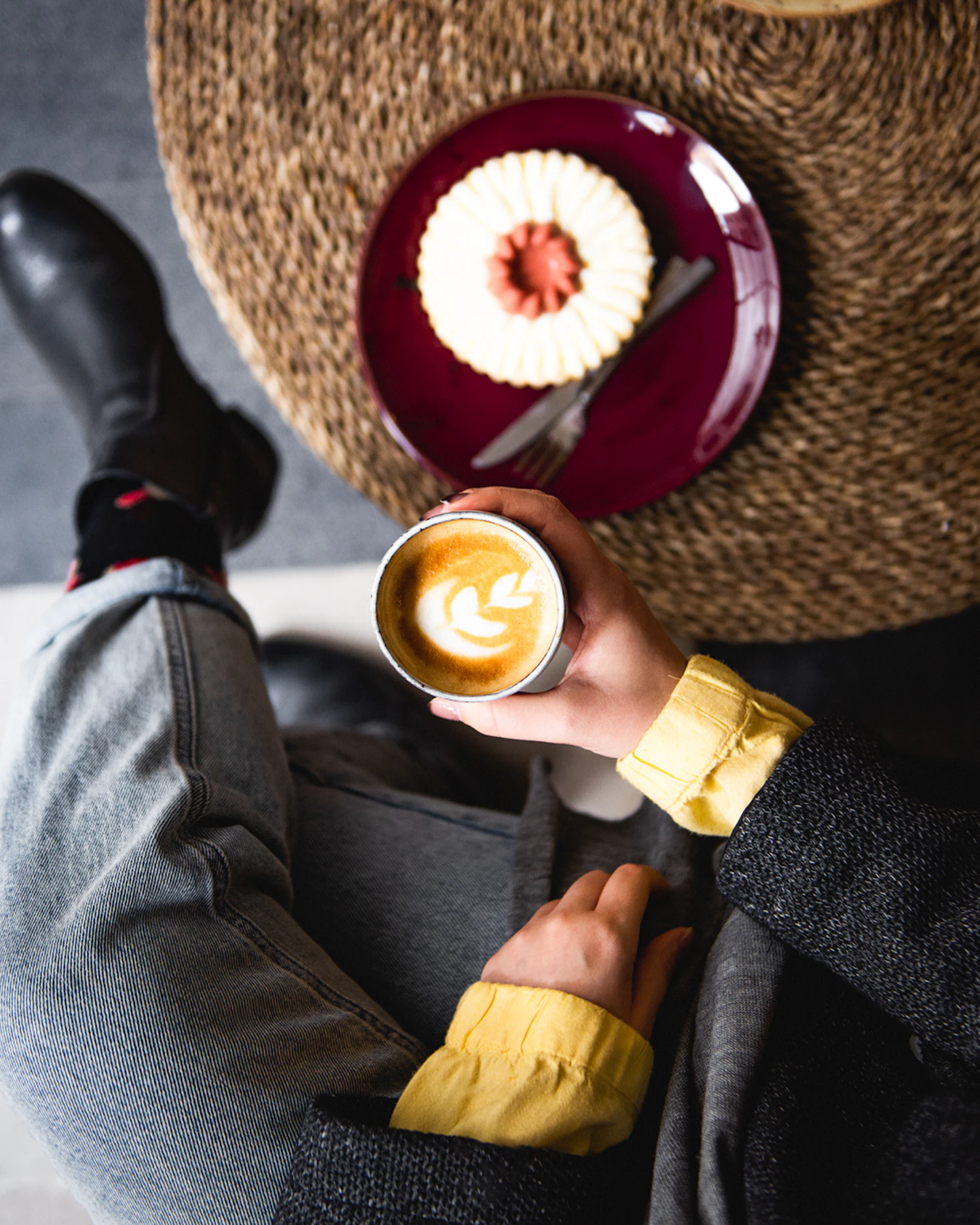 Person mit Latte und Dessert als Symbol für bewussten Genuss statt automatisches Snacken