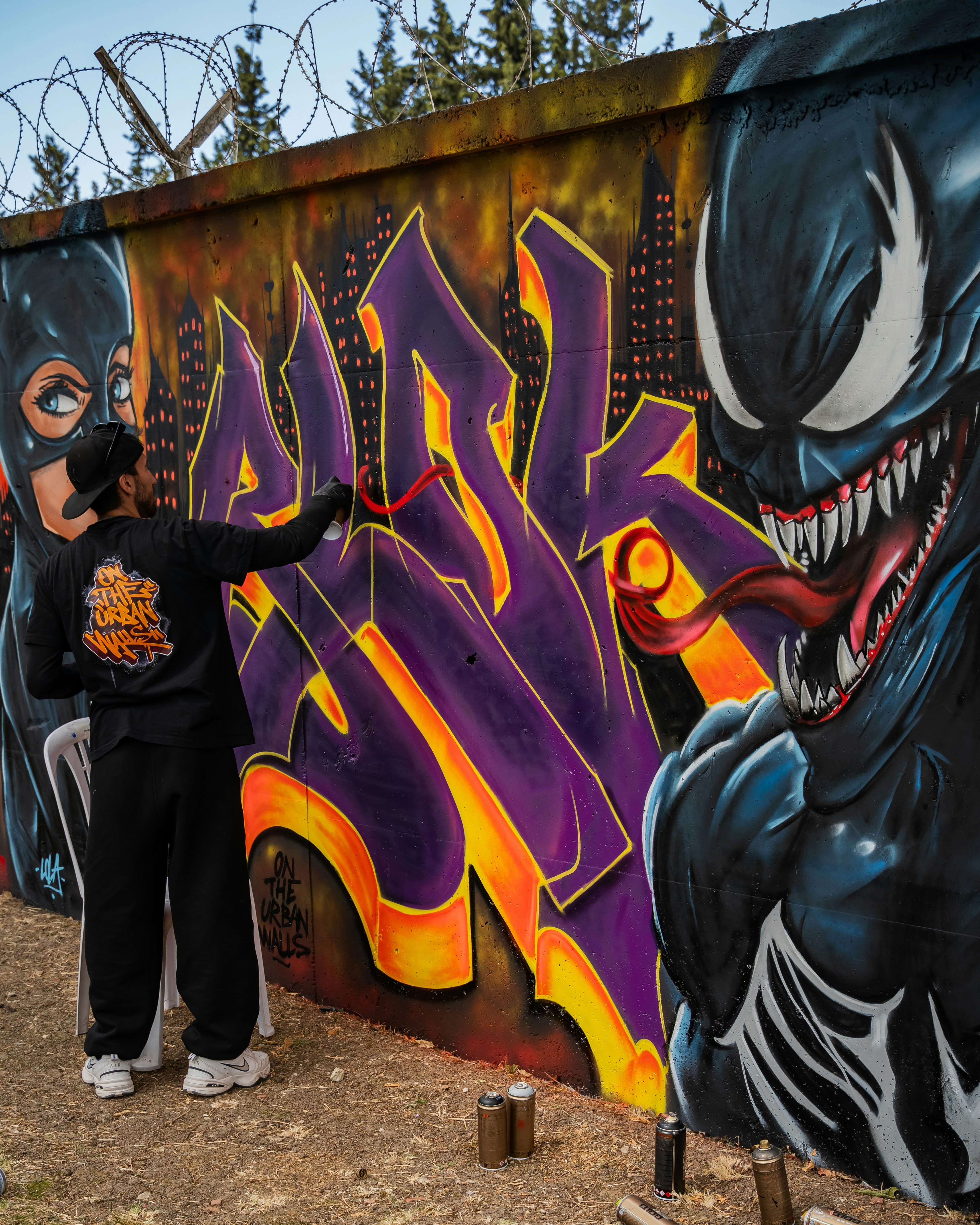 L'artista spruzza graffiti su un muro con veleno.