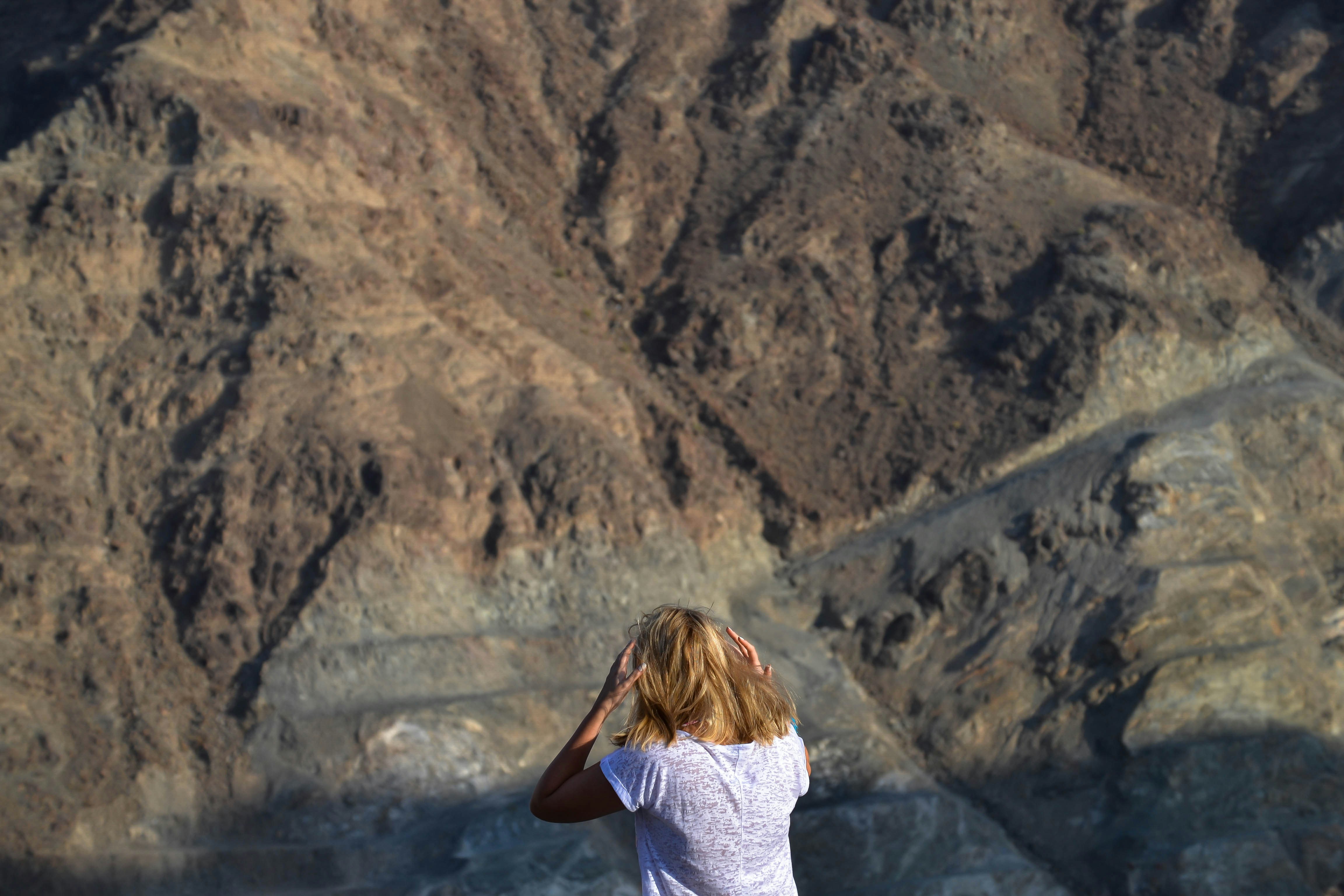 Wanita melihat lanskap pegunungan yang terjal
