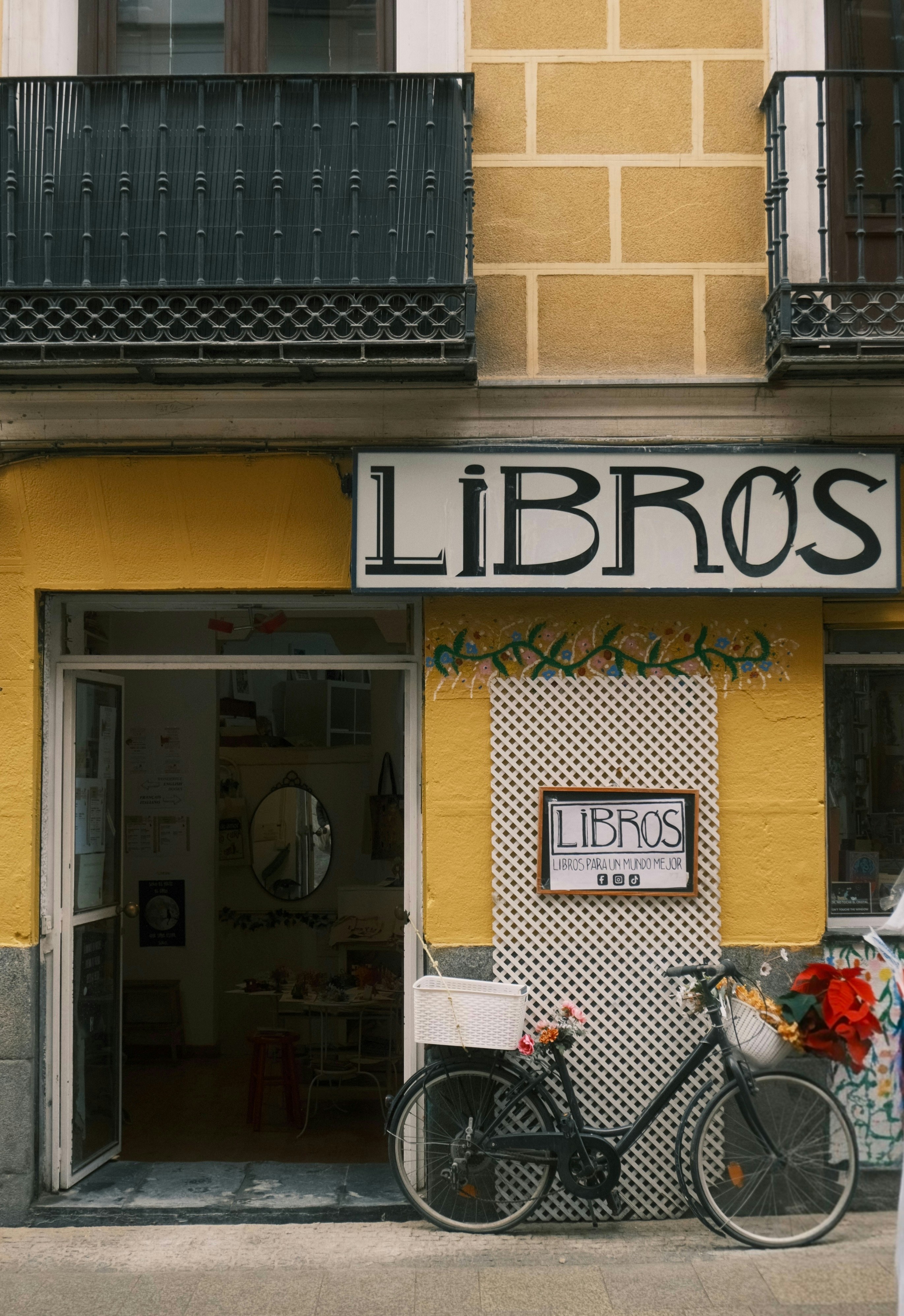 A bicycle parked outside a bookstore entrance.