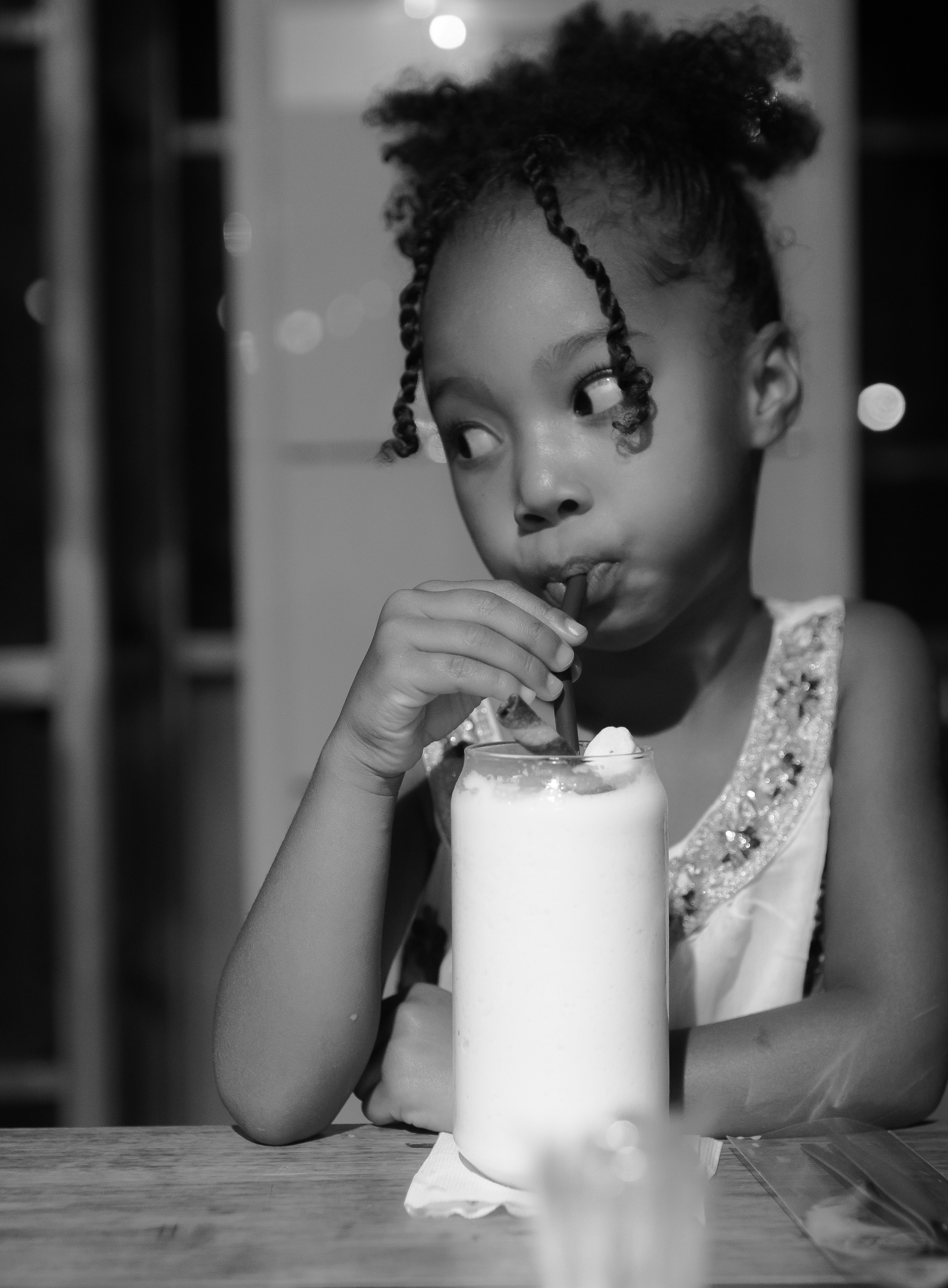 Una ragazzina beve un frappè con una cannuccia.