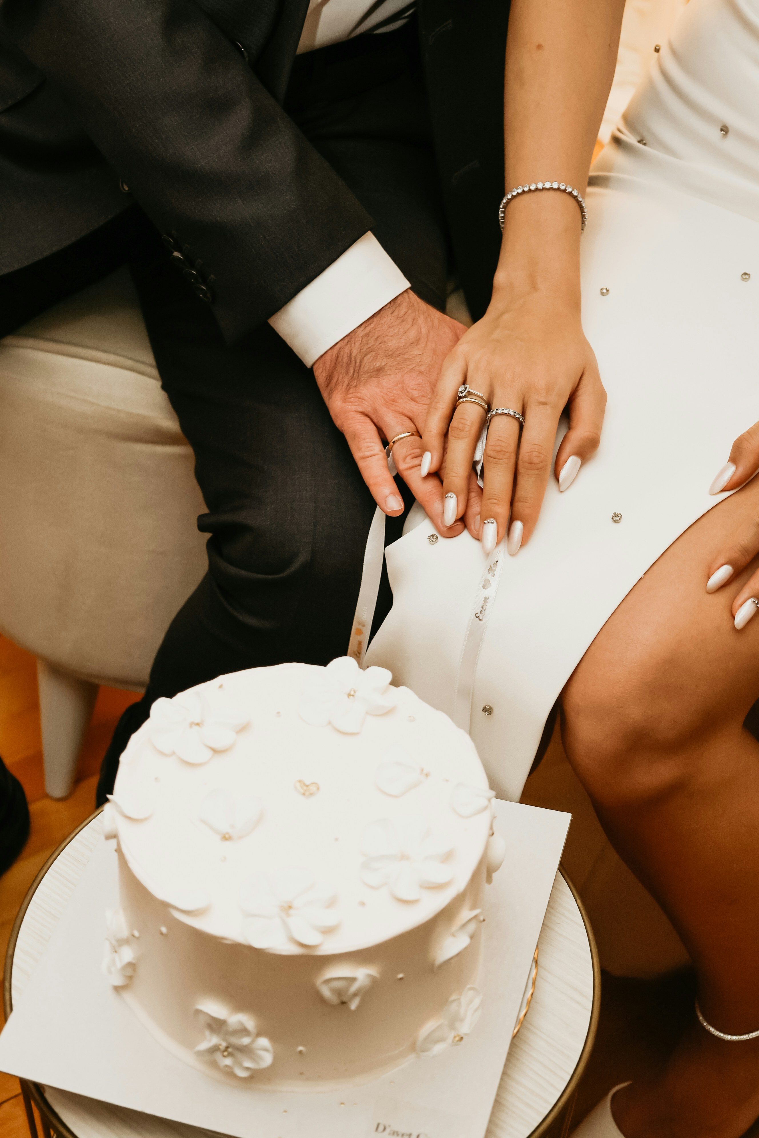 Entregas do casal sobre um bolo de casamento branco