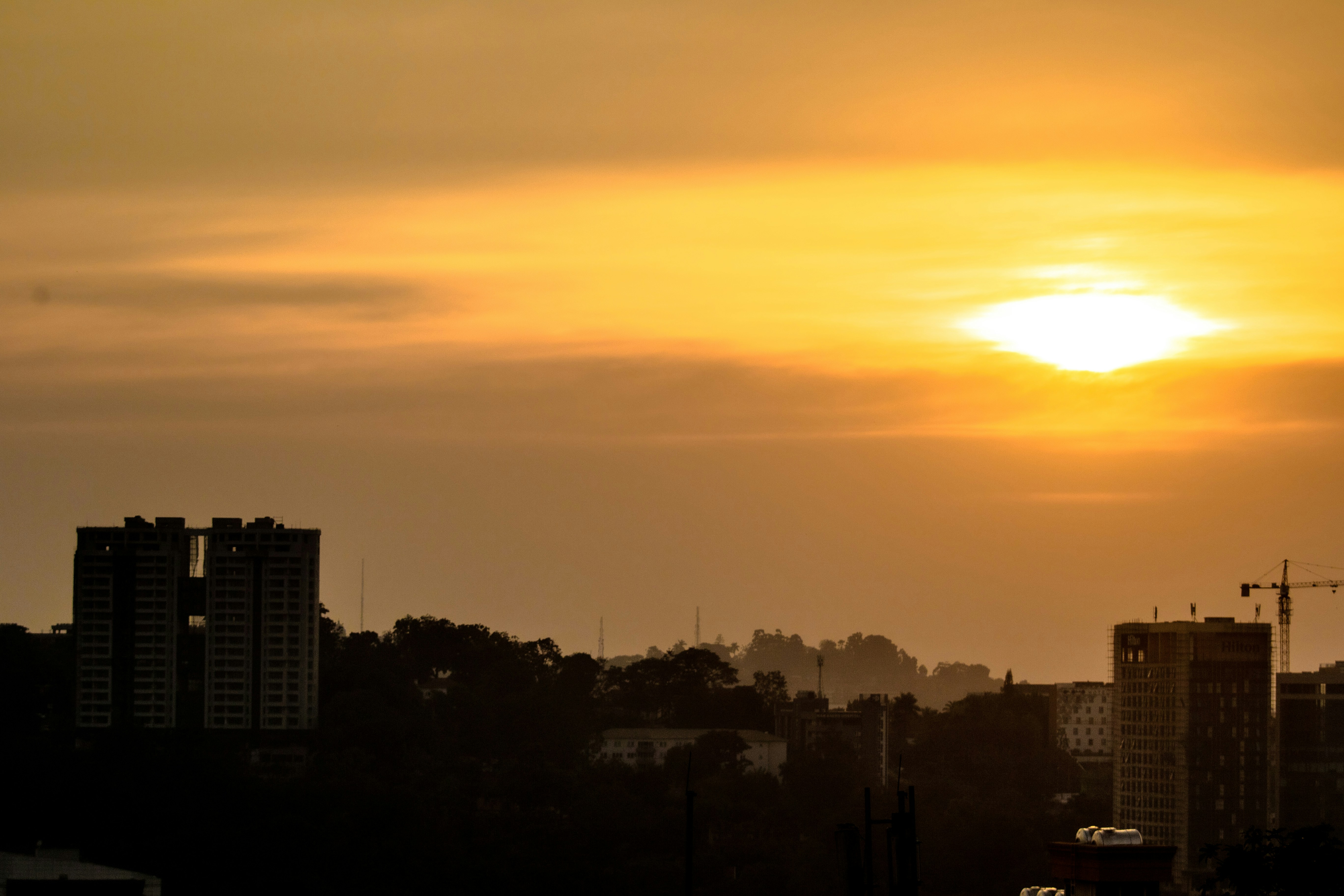 Sunset over a city skyline with buildings.