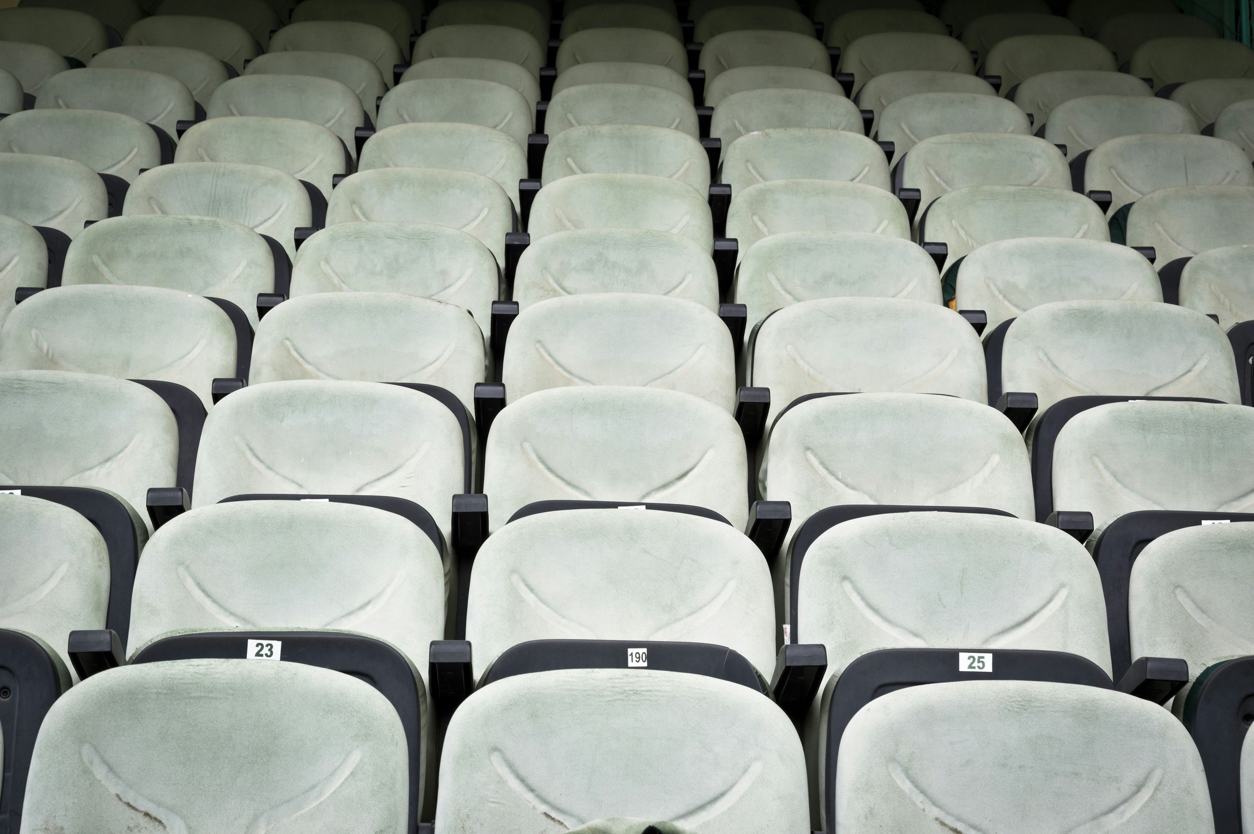Rows of empty stadium seats in a muted tone.