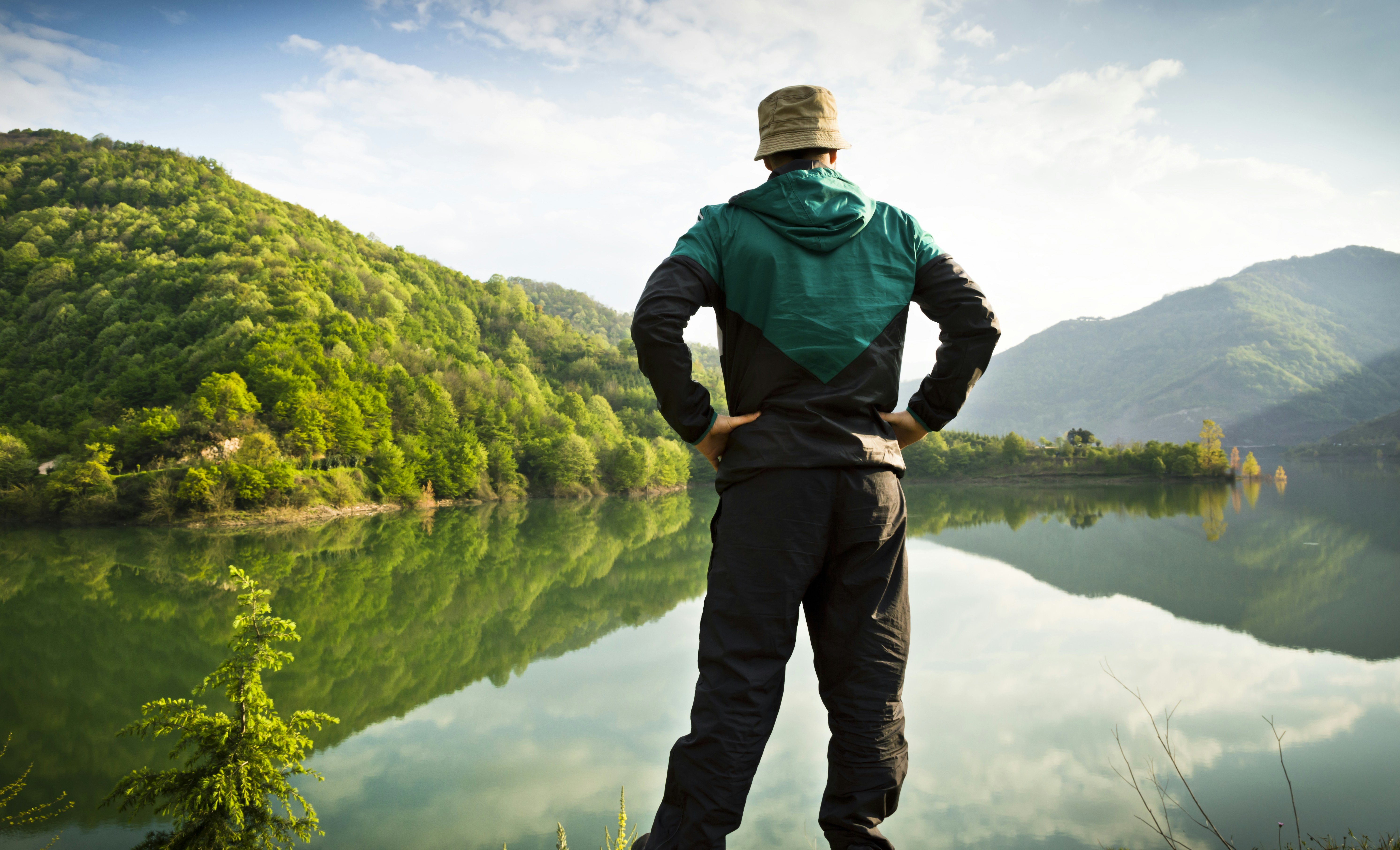 Man looking at a serene mountain lake
