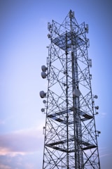 A tall telecommunications tower against a blue sky.