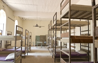 Bunk beds fill a dimly lit dormitory room.