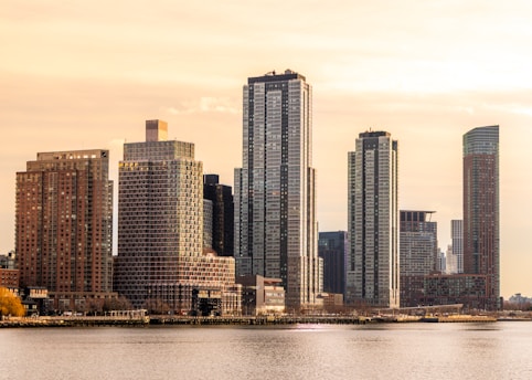 Modern skyscrapers rise above a calm body of water.