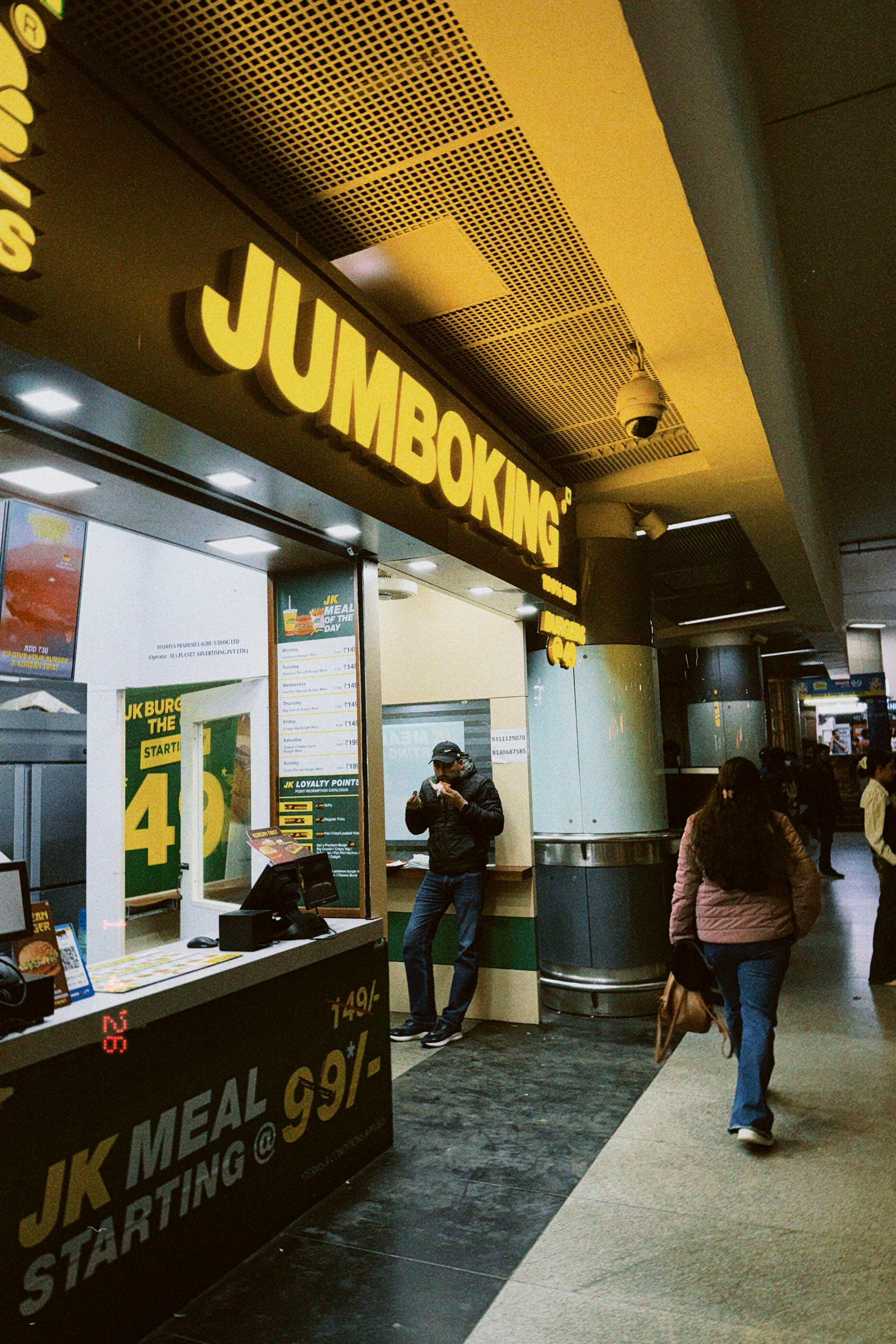 People walk past a jumboking fast food restaurant.