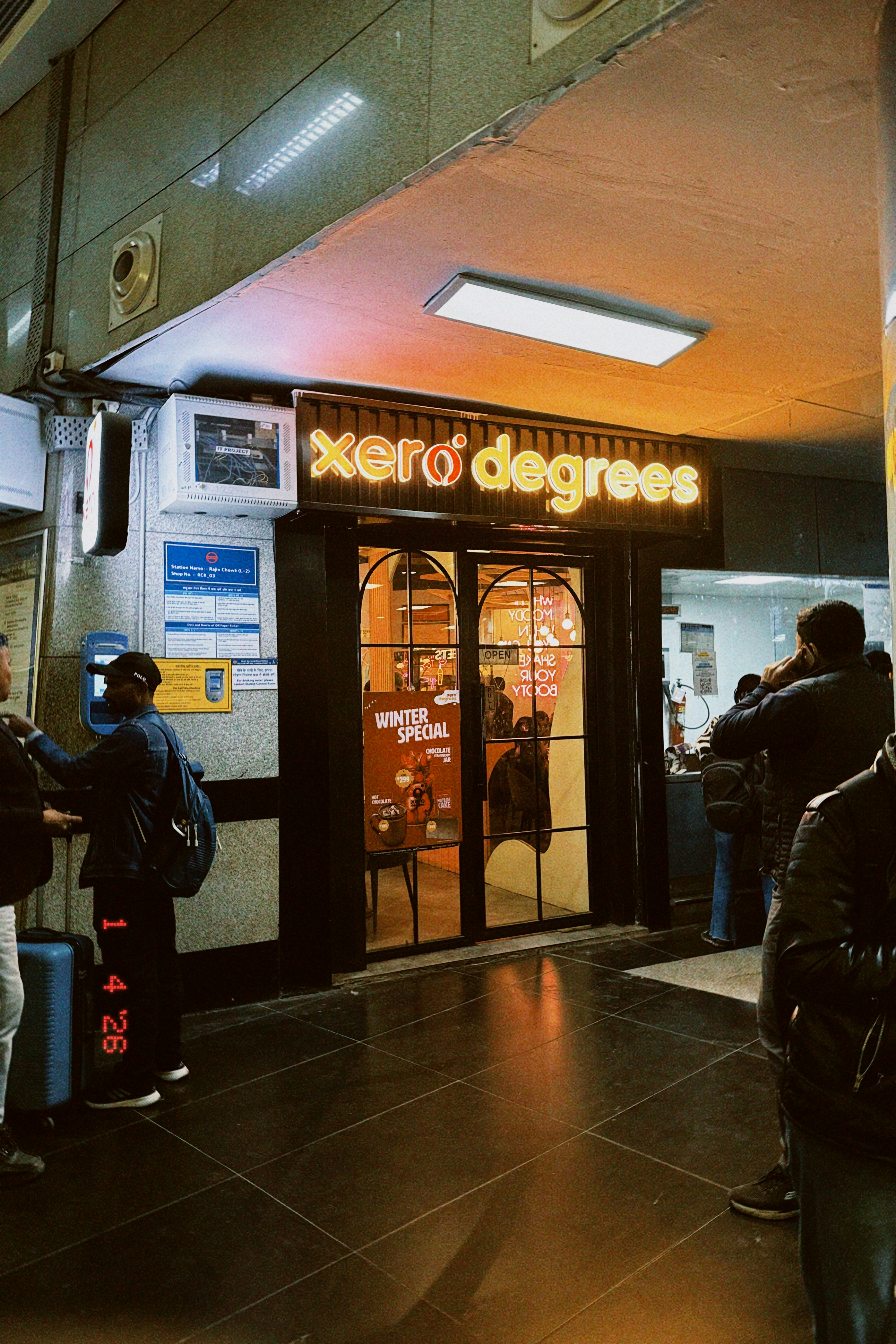 People outside a "xero degrees" restaurant at night