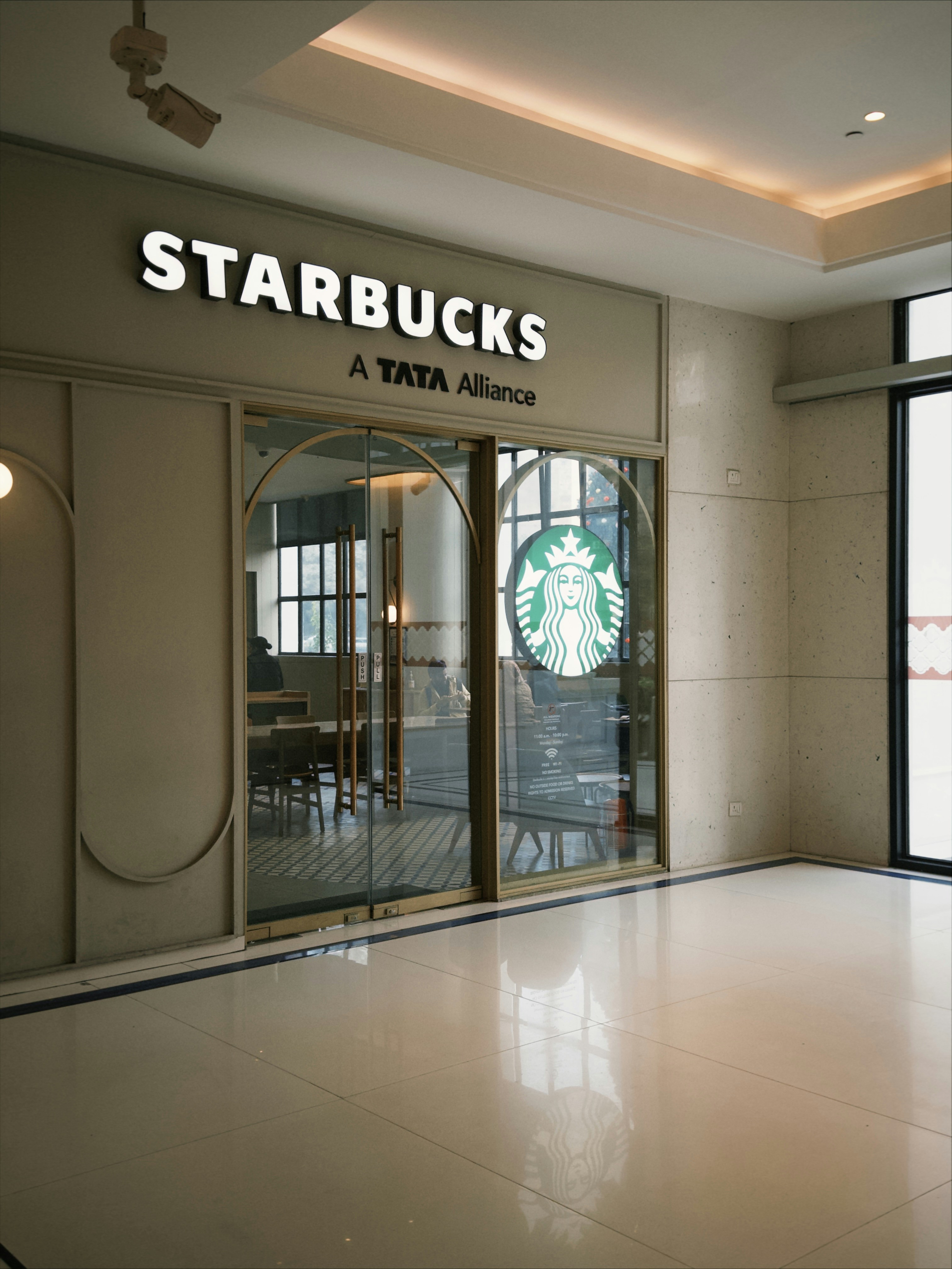 스타벅스 매장 입구에 불이 켜진 간판과 로고가 있습니다. 사진 – Unsplash의 무료 카페 이미지