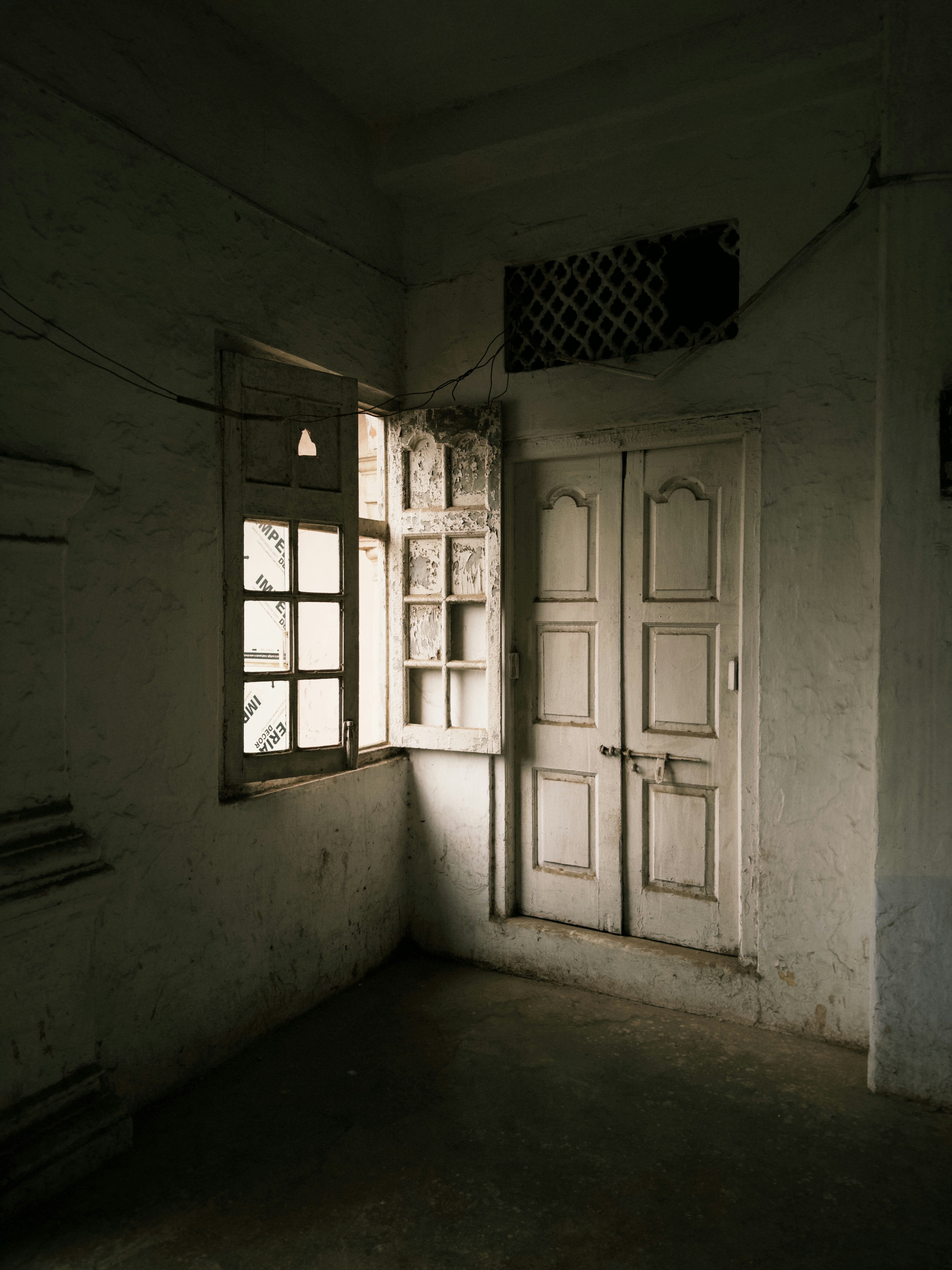 Dim room with an open window and closed doors