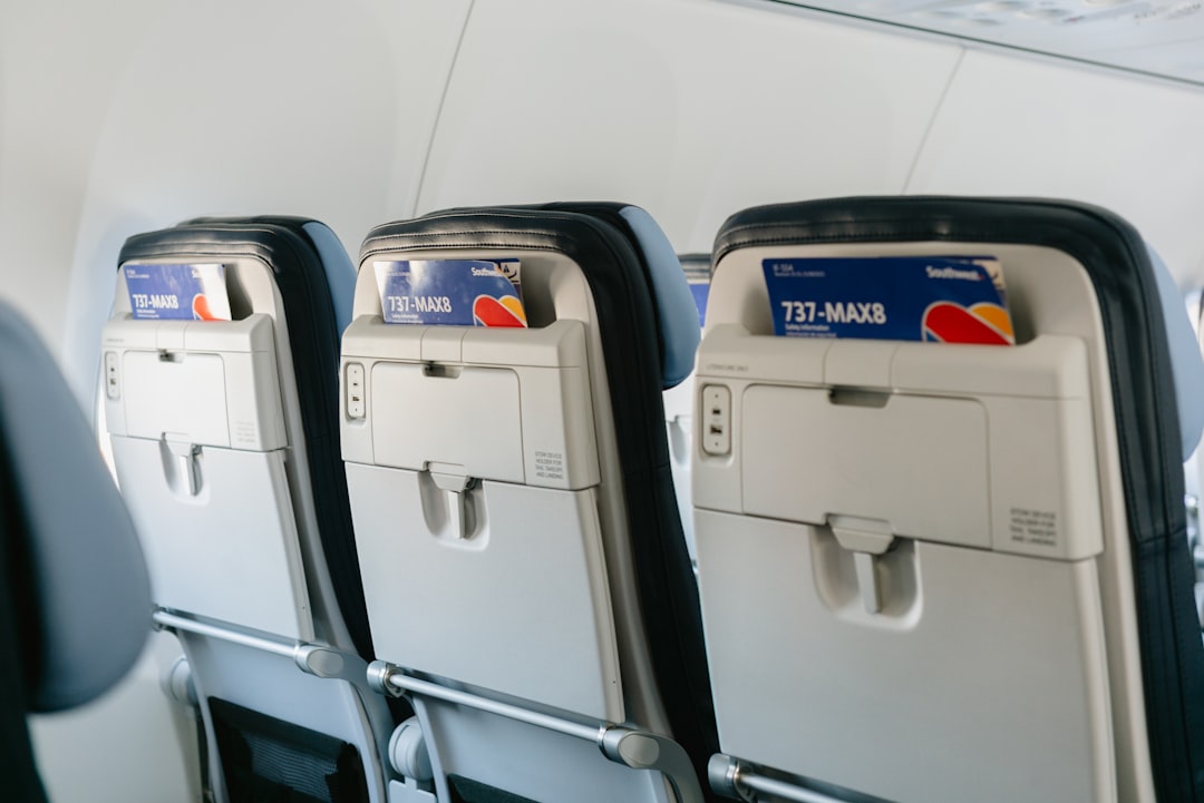 Rows of empty airplane seats facing forward.