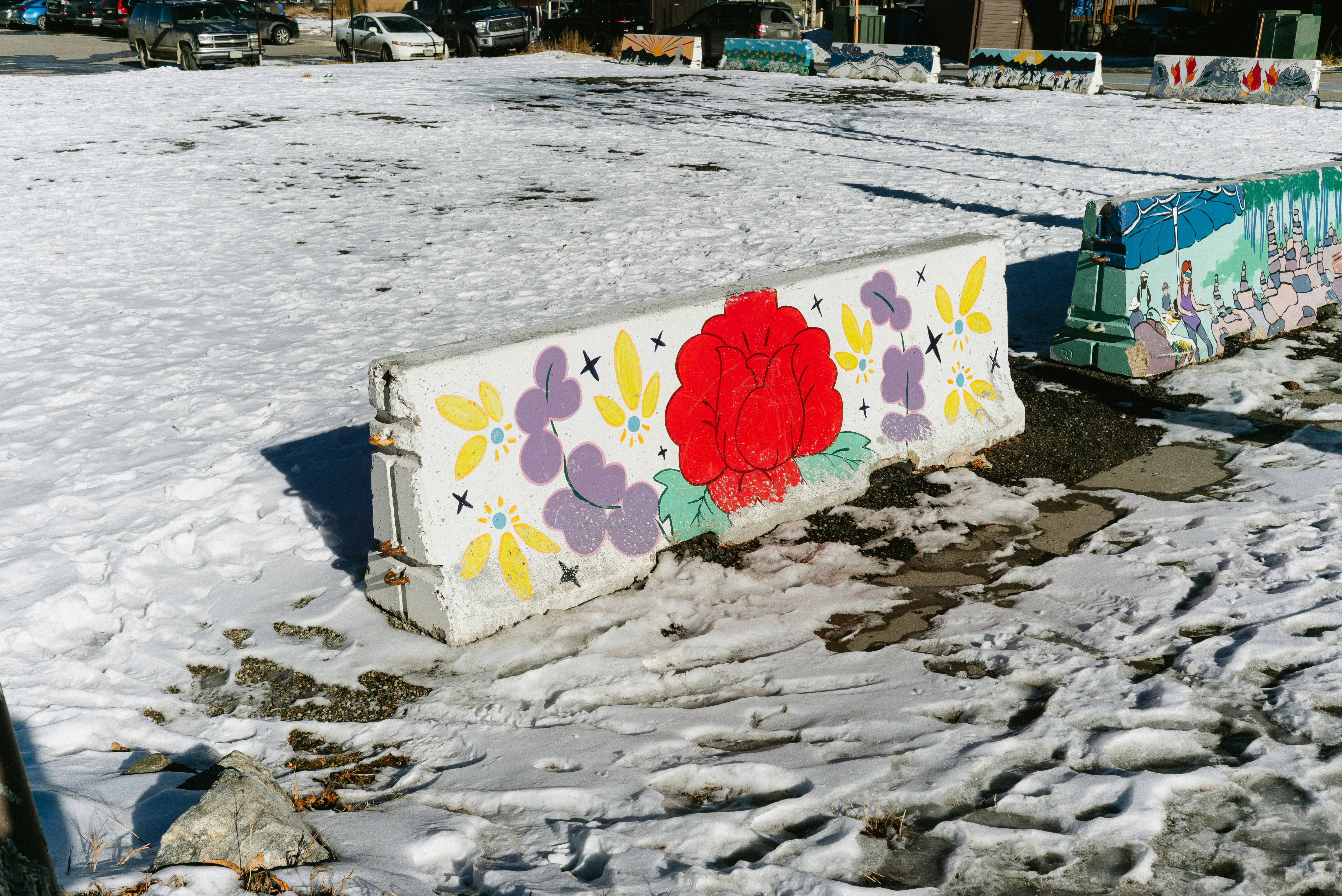 Betonbarriere, bemalt mit Blumen und Sternen