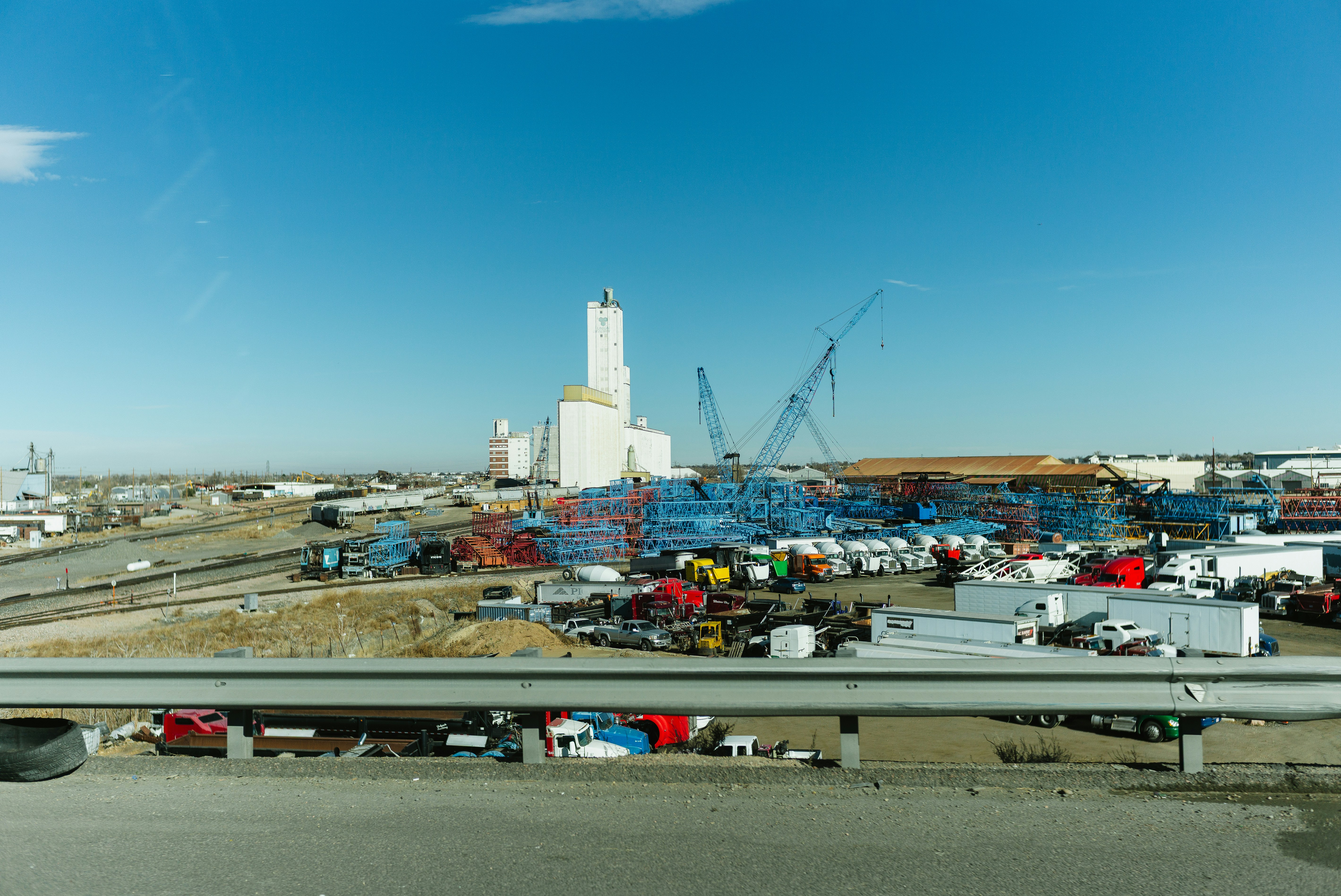 Complexe industriel avec silos et grues de chantier