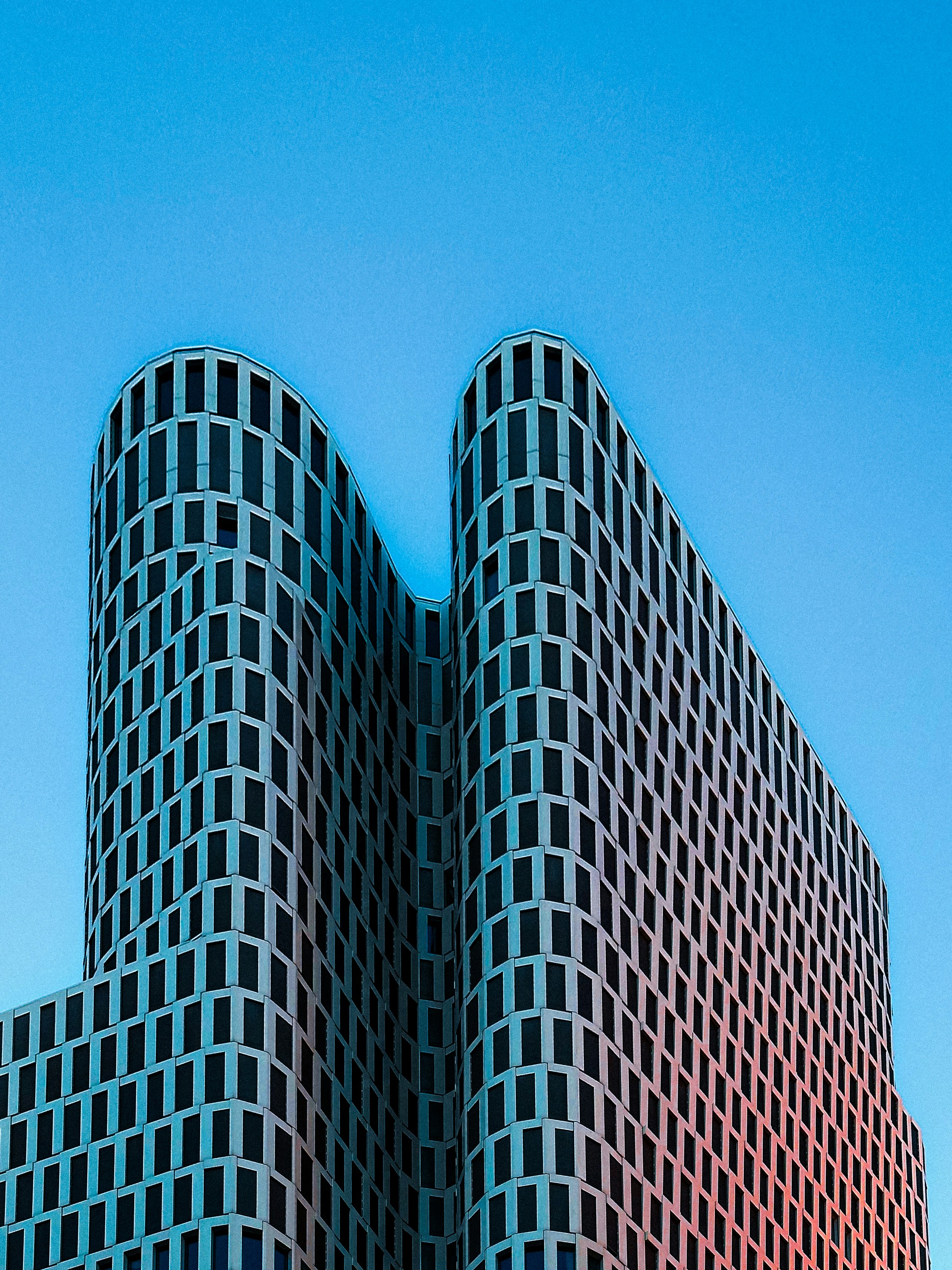 Modern skyscraper with curved facade against blue sky