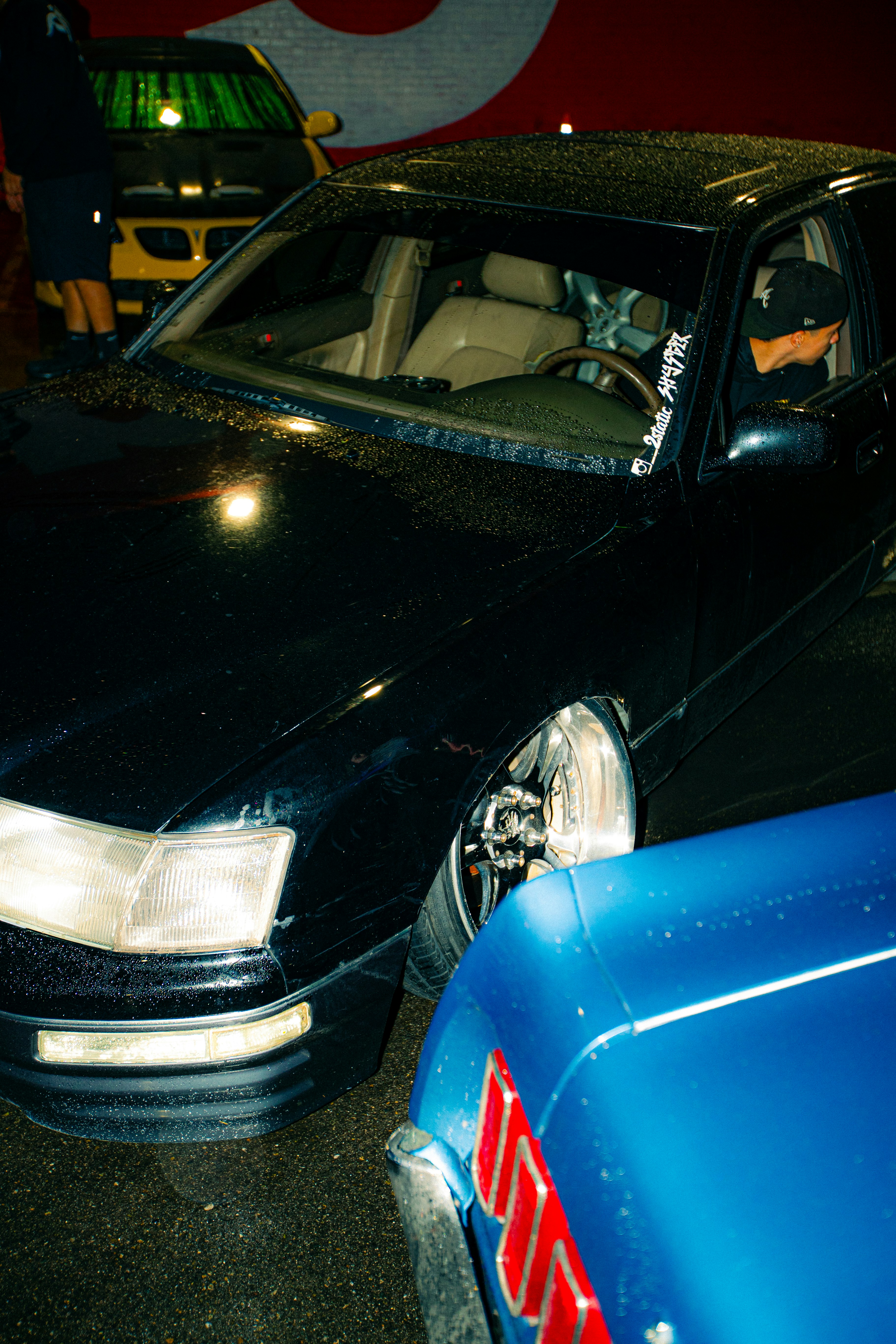 Two cars parked closely together at night.