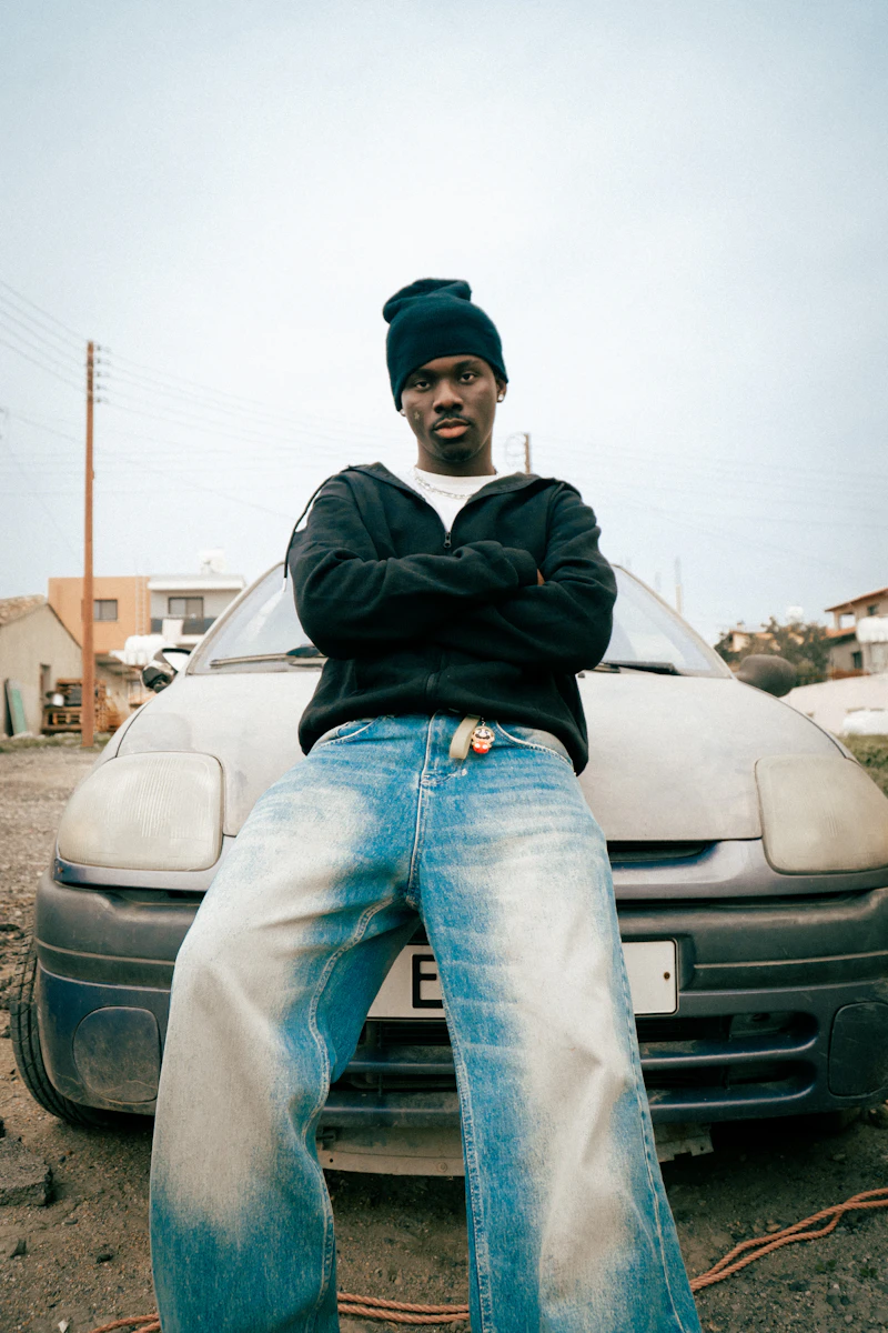 Baggy jeans leaning on a car hood
