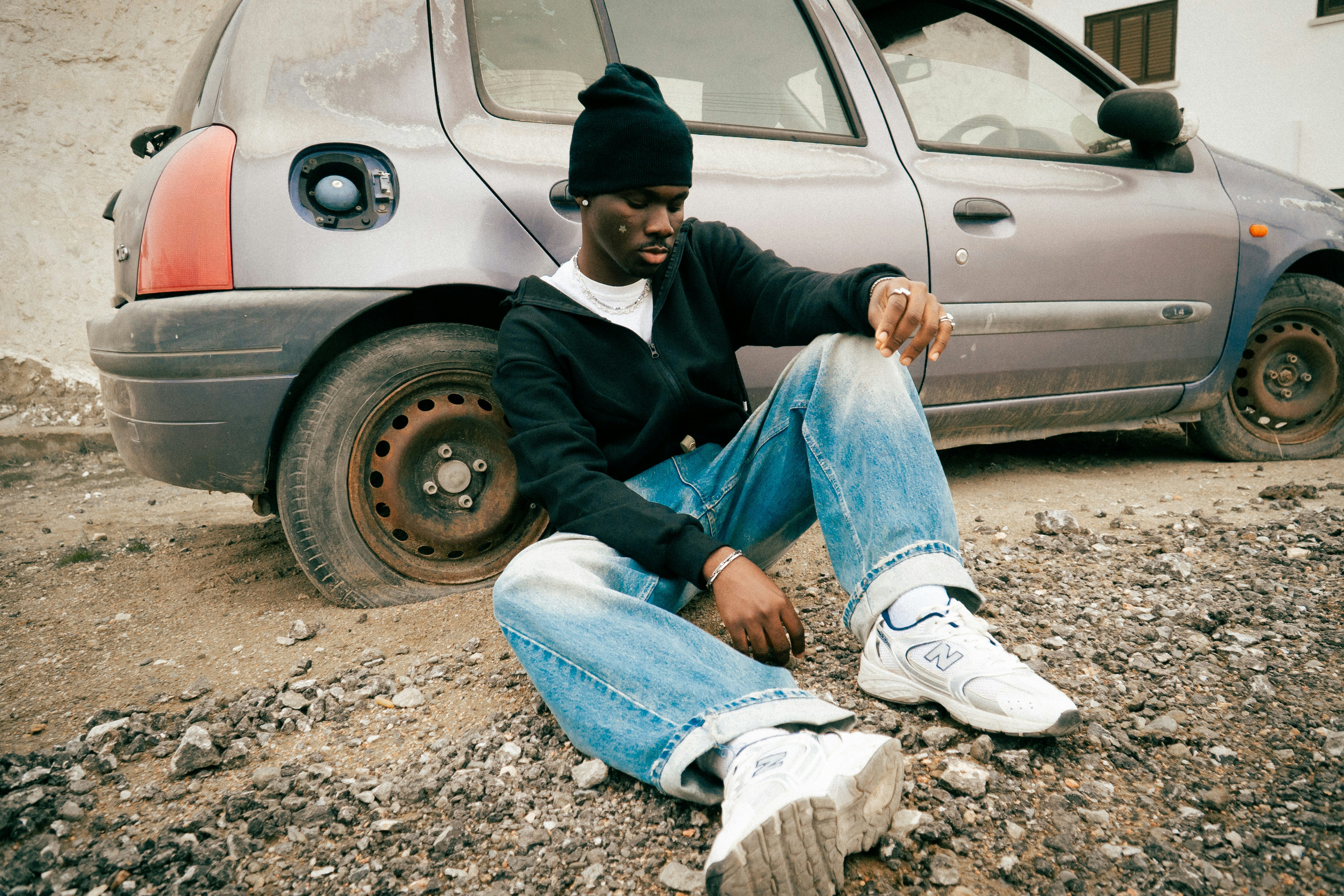 Man sitting by a broken-down car