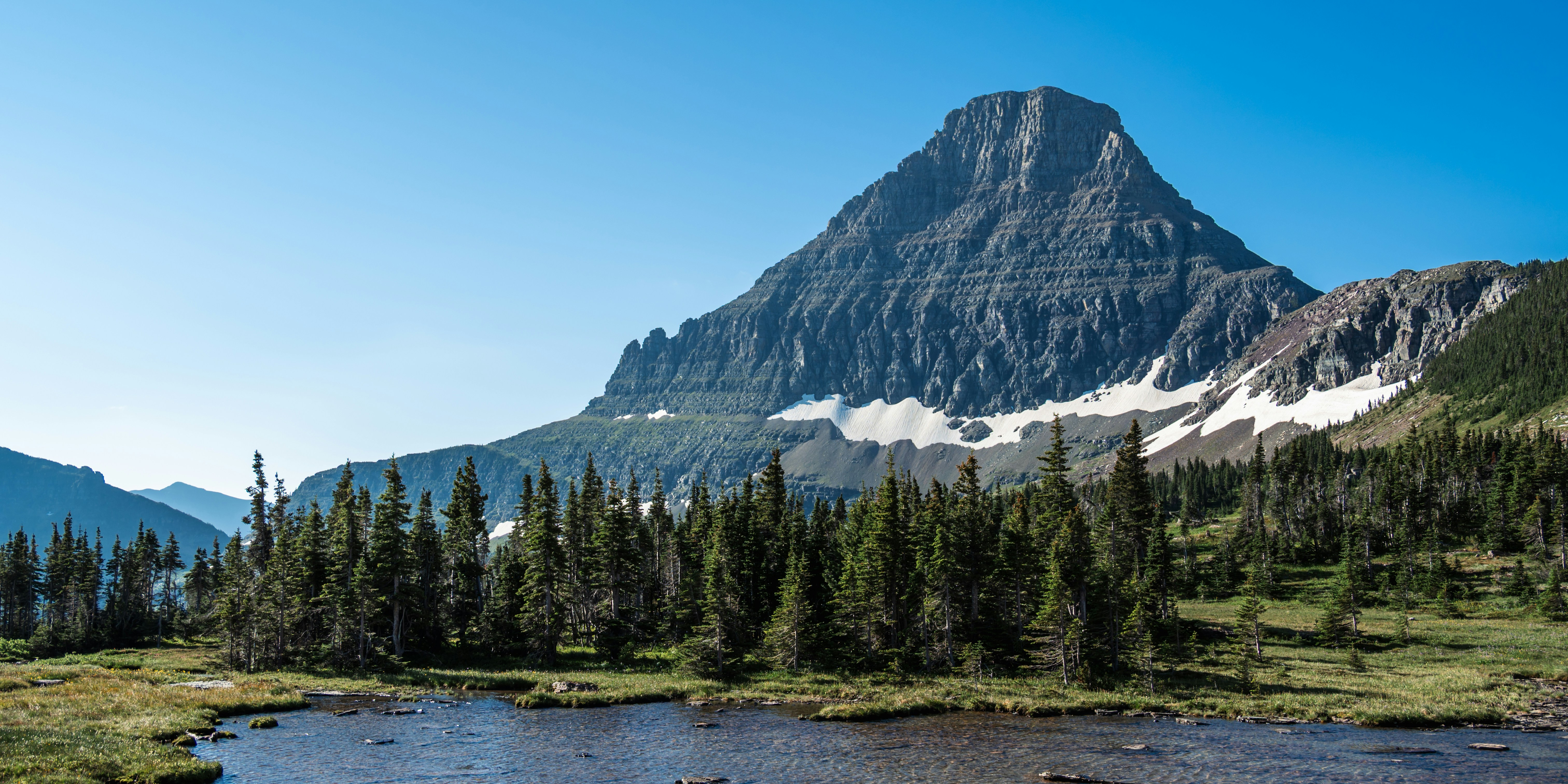 A majestic mountain peak rises above a serene alpine lake.