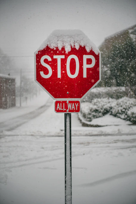 Stop sign covered in snow during a blizzard