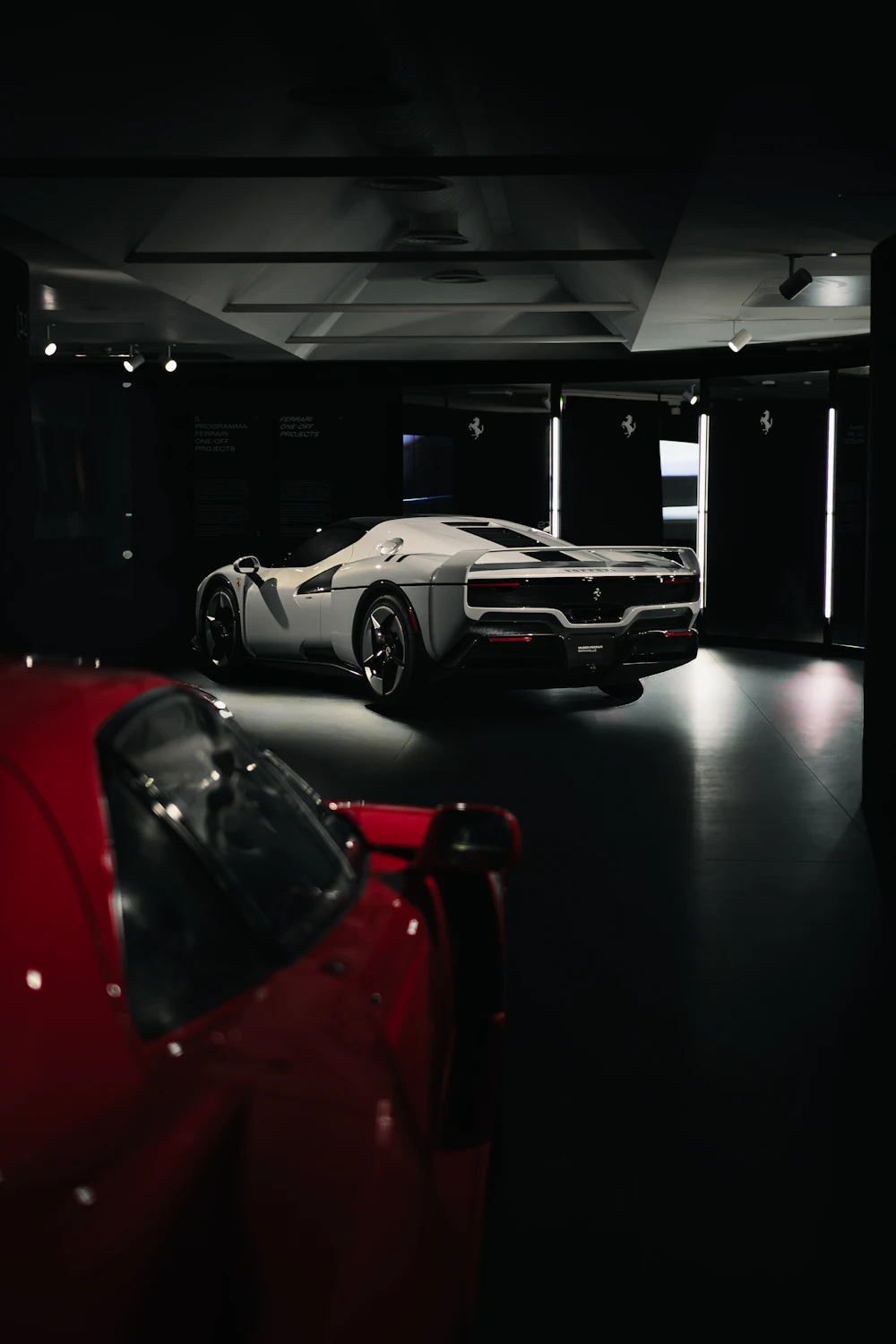 Two sports cars in a dark showroom