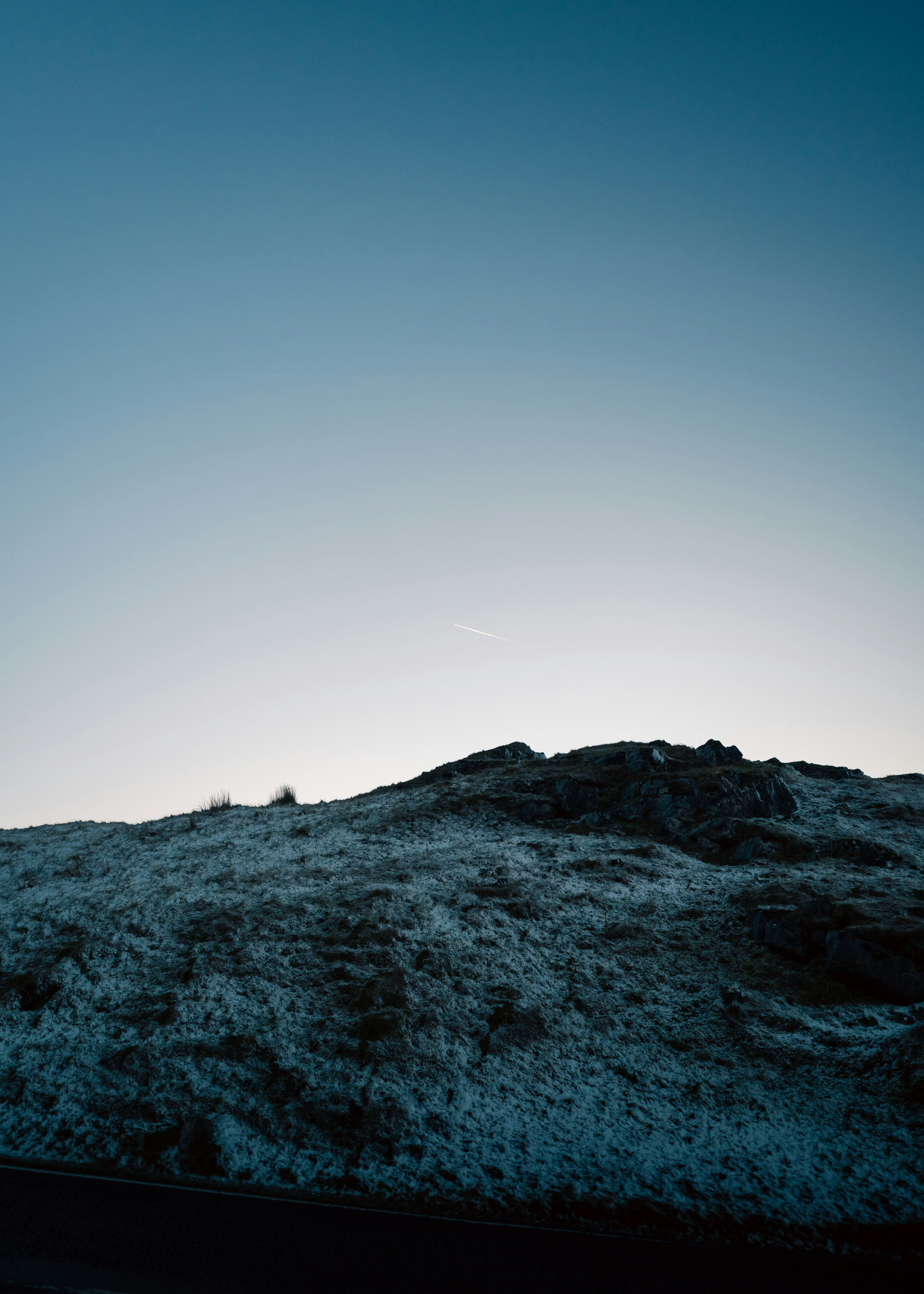 Frozen grassy hill under a clear blue sky