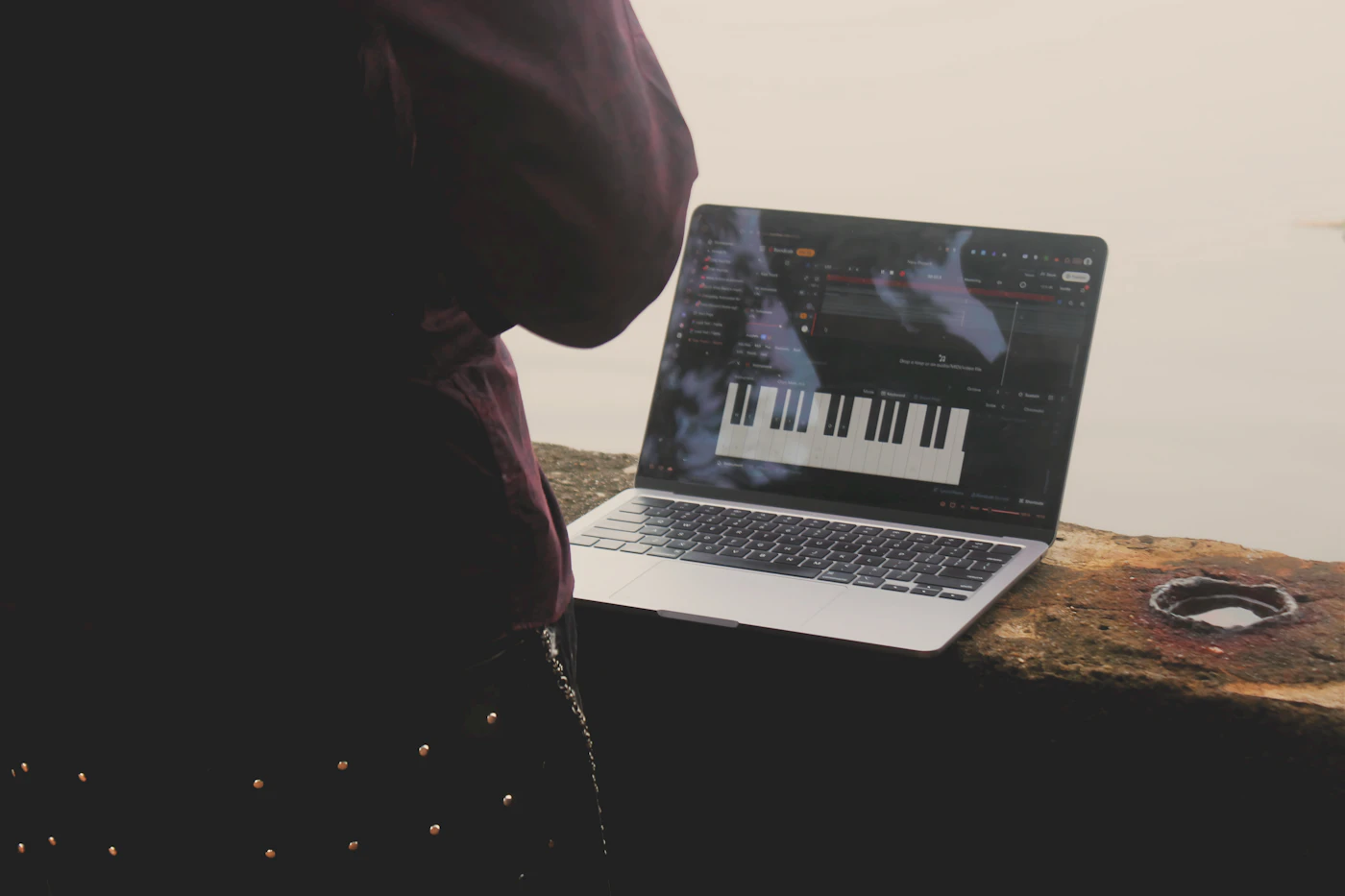 Musisi bekerja dengan laptop dan perangkat produksi musik untuk meninjau data katalog digital
