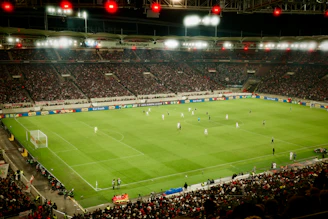 Soccer game played in a packed stadium at night