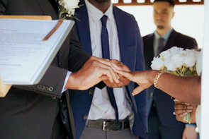 Groom placing ring on bride's finger during wedding ceremony