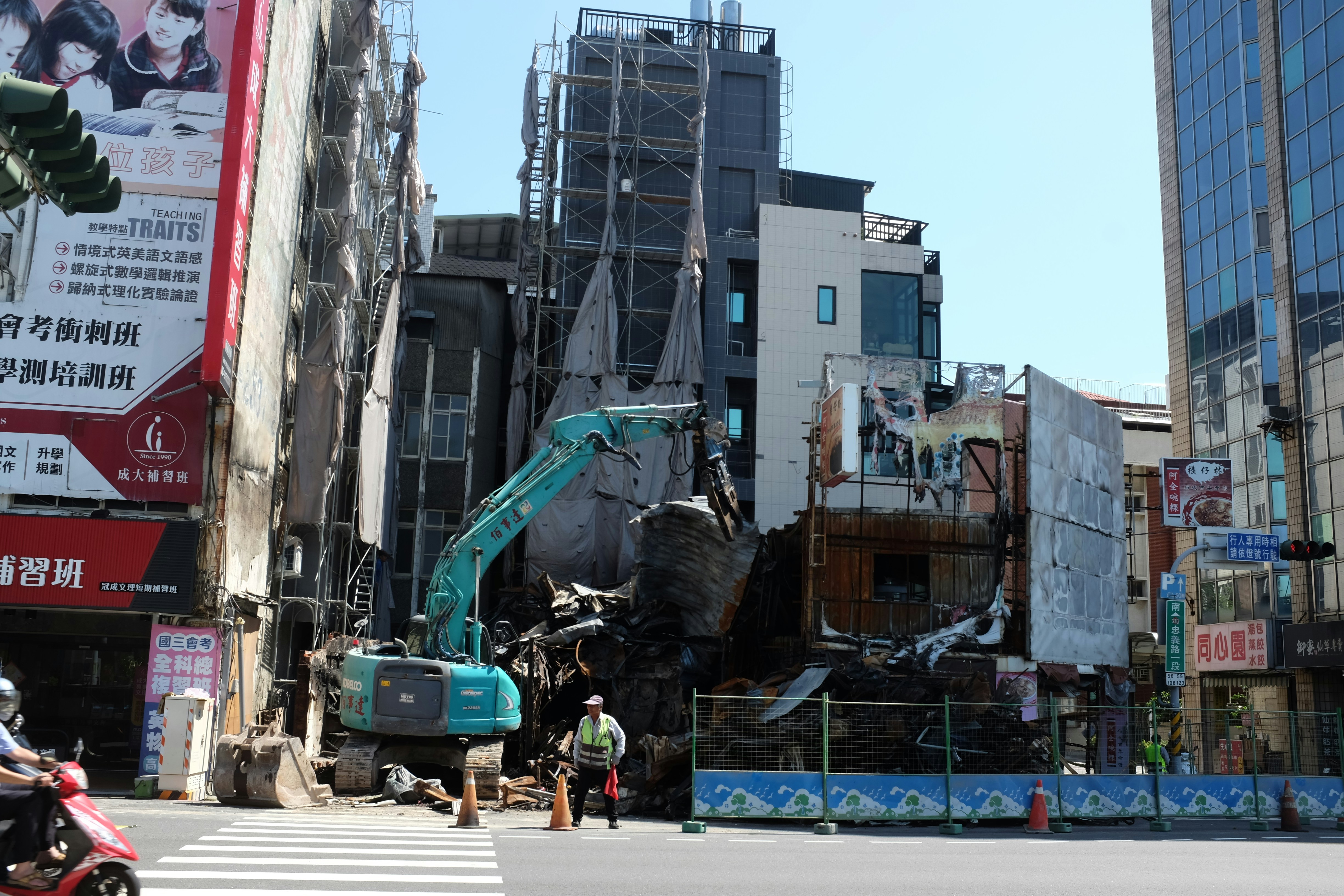Excavator demolishes building on city street.