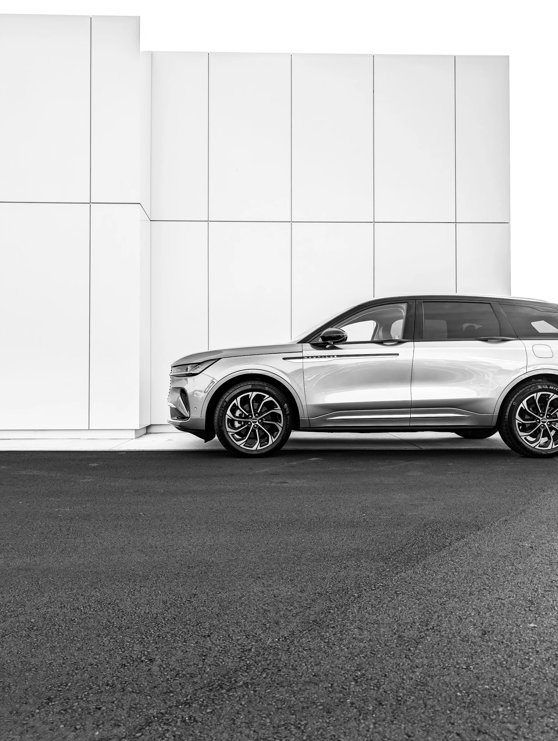 Silver suv parked next to a modern white building