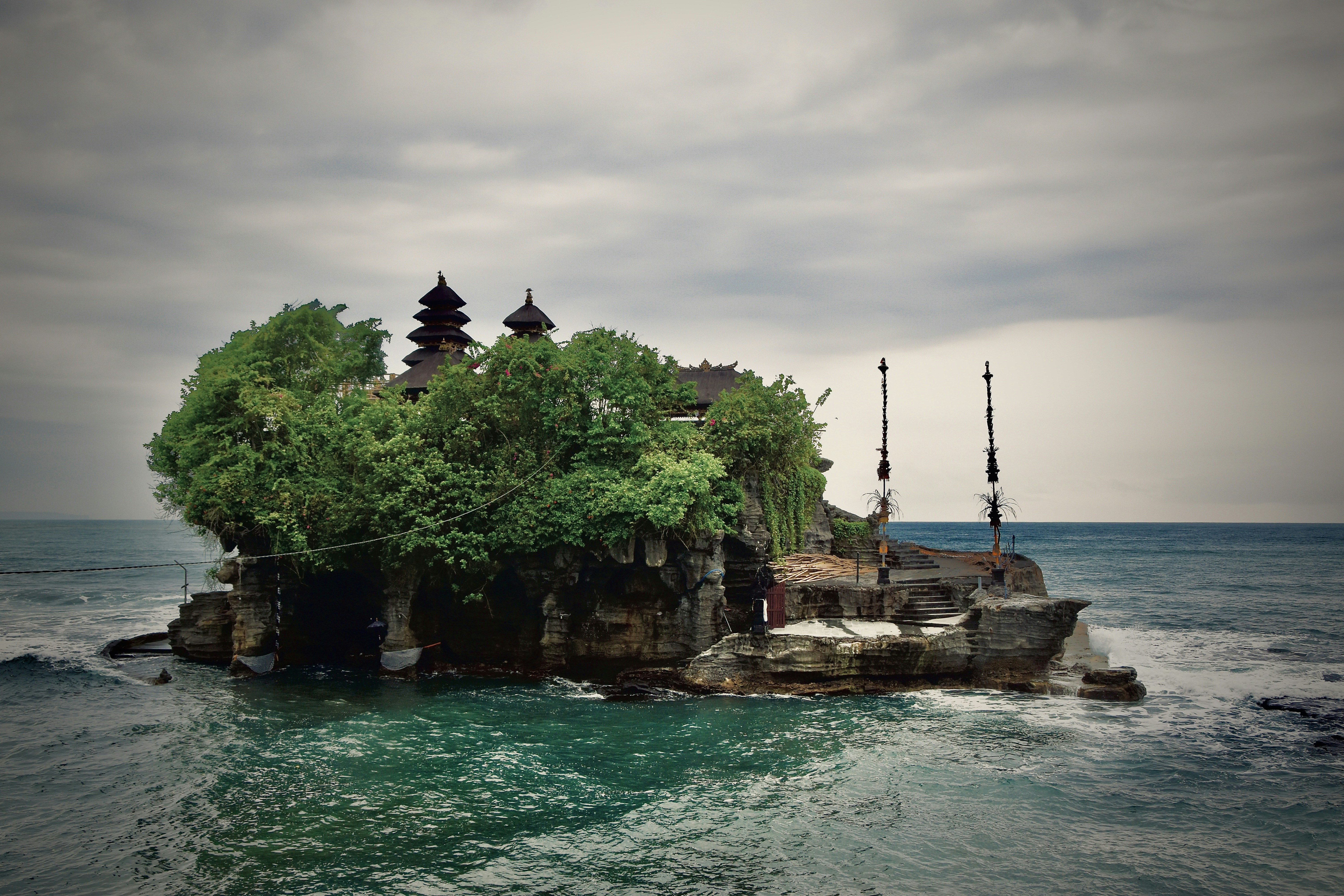 바위 섬에 있는 사원, 바다 파도로 둘러싸여 있다