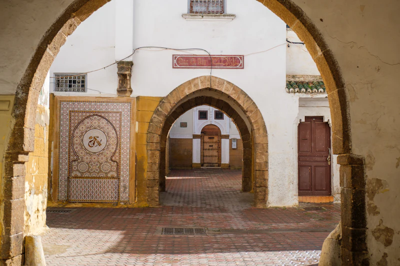 An arched entryway to a Moroccan courtyard with tile work