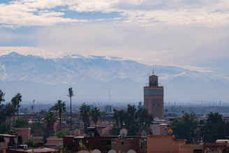Mosque tower with snow-capped mountains in background