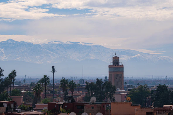 Mosque tower with snow-capped mountains in background