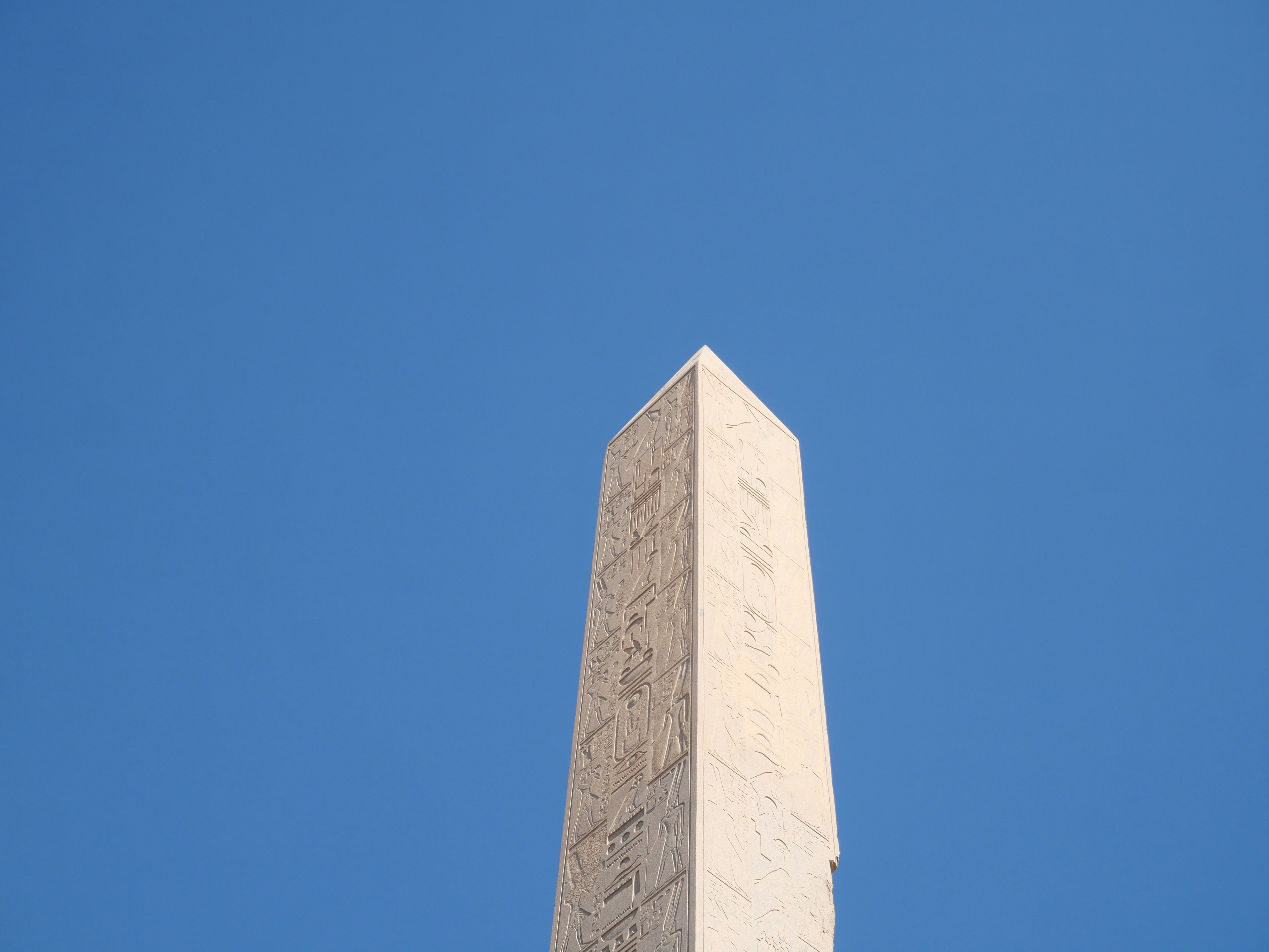 Ancient obelisk against a clear blue sky