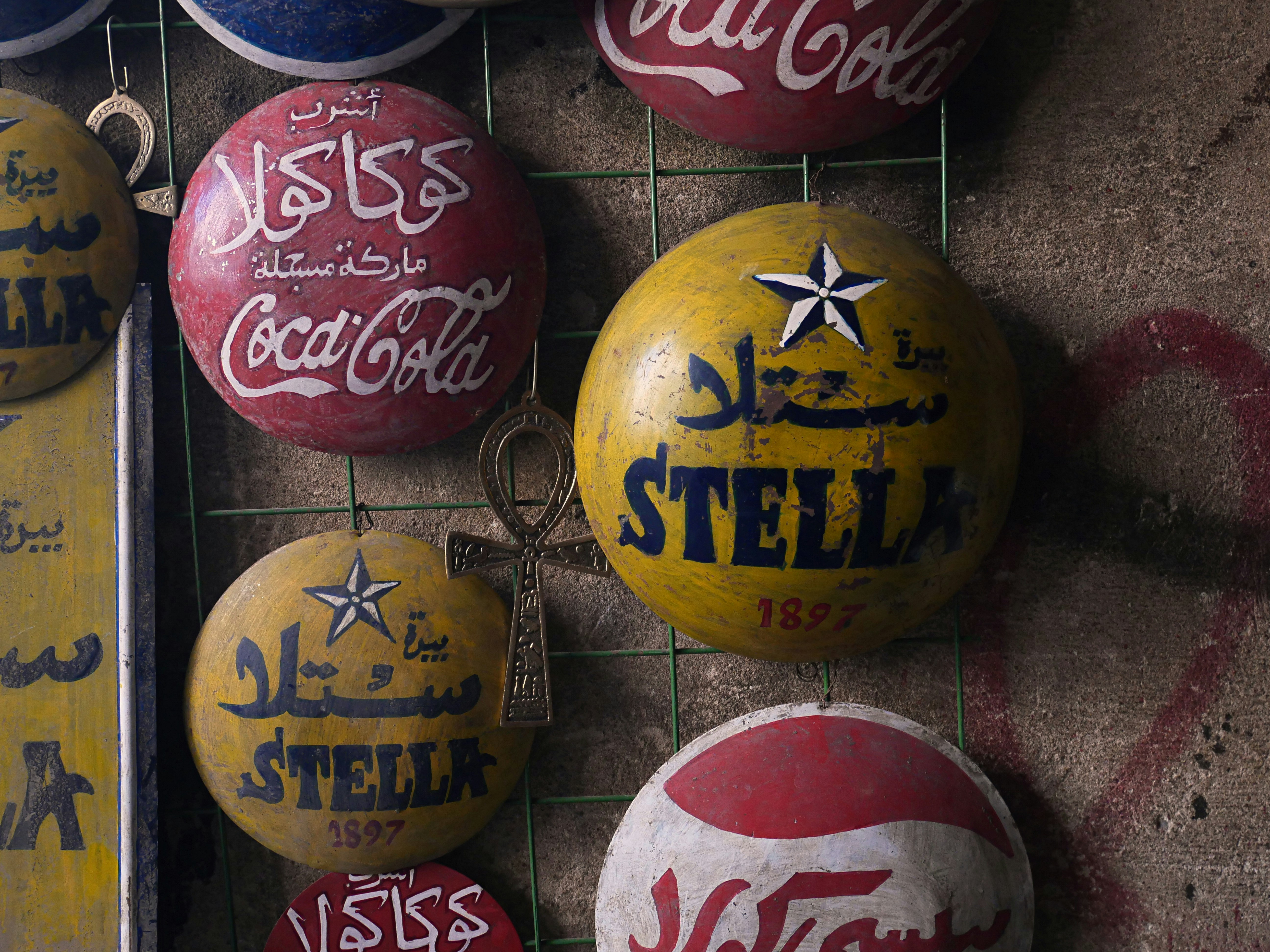 Collection of vintage coca-cola and stella beer badges.