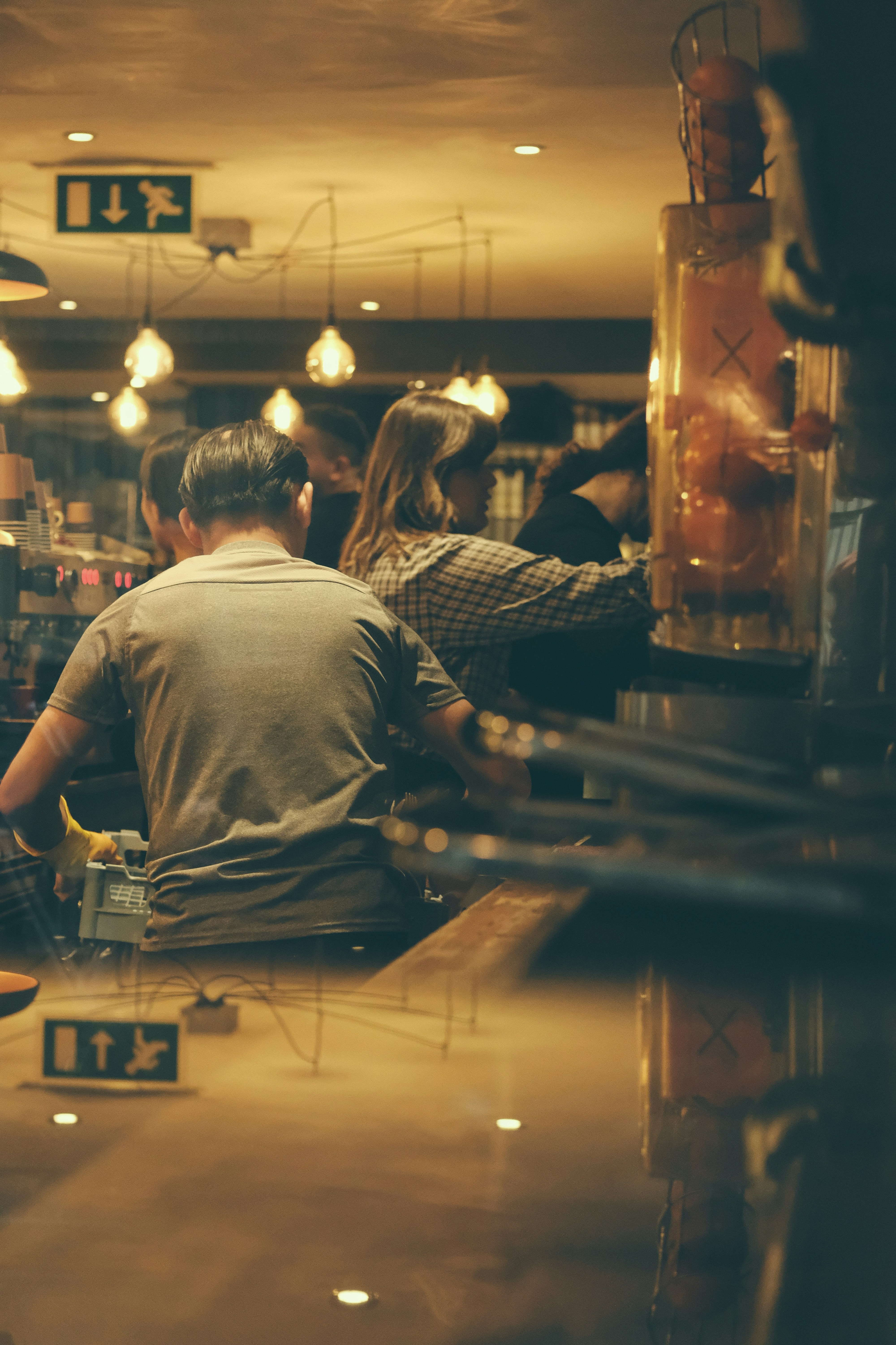 People working behind a counter in a cafe.