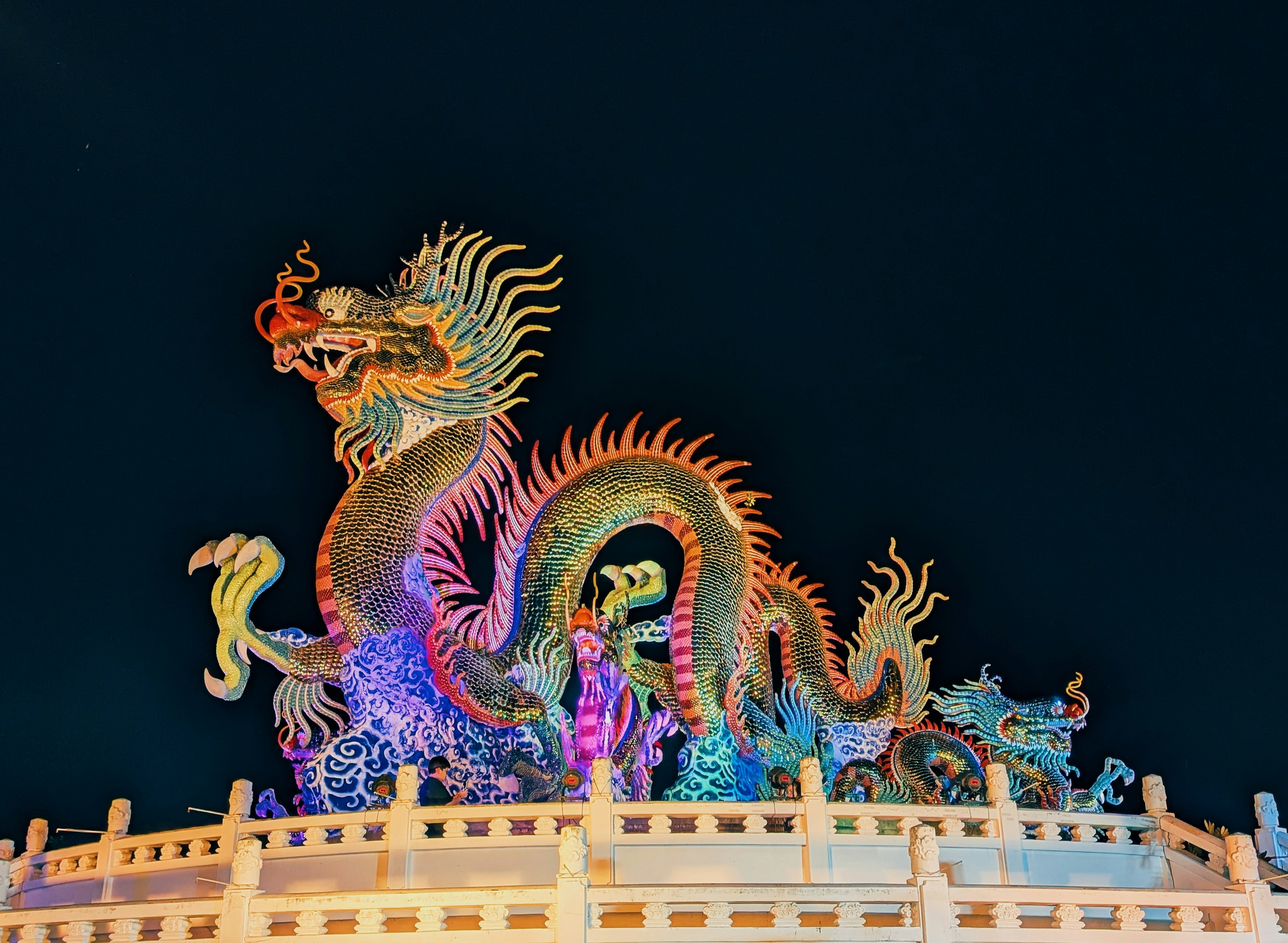 Colorful dragon sculpture illuminated at night