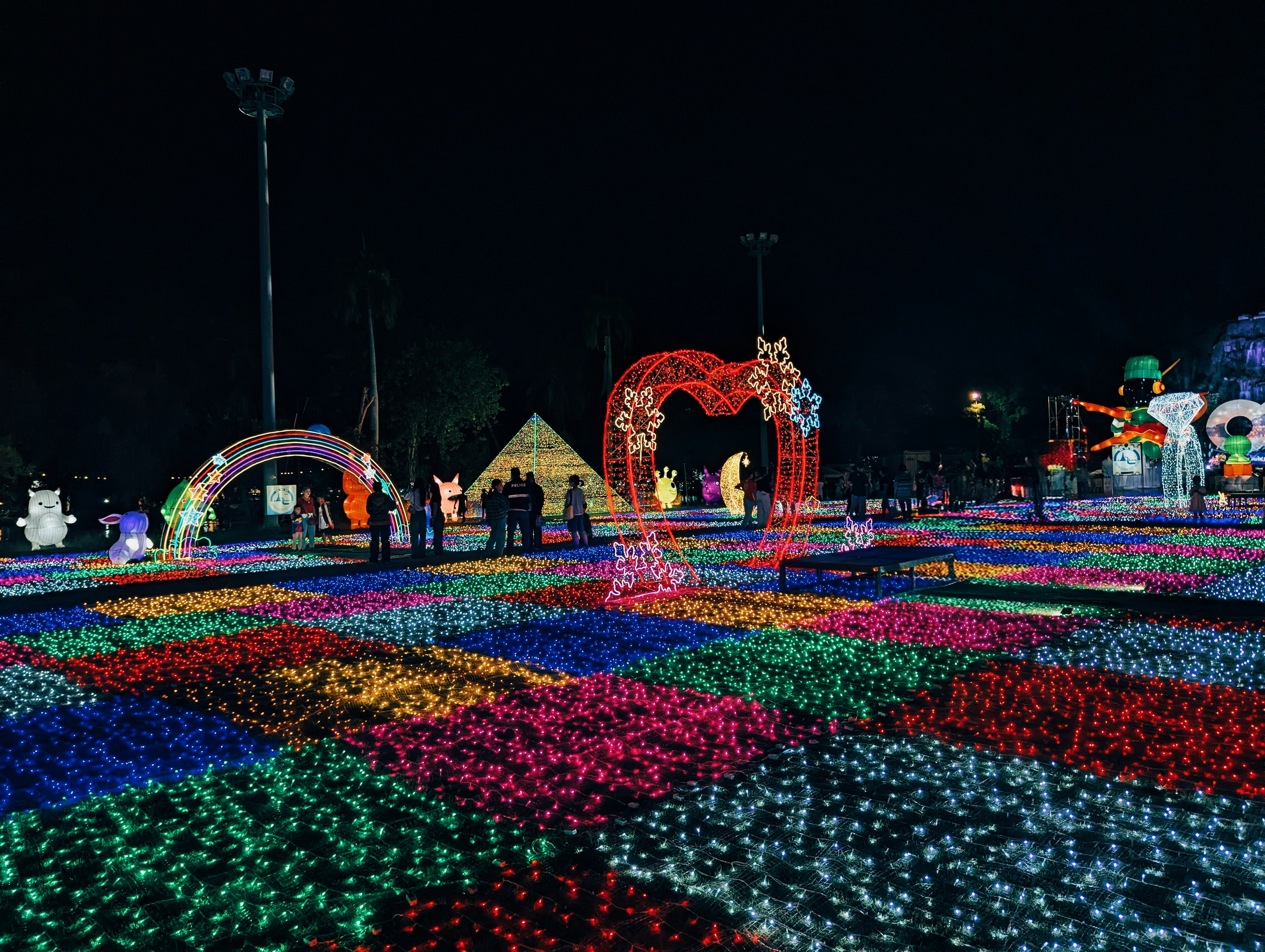 Colorful light display at night with people walking