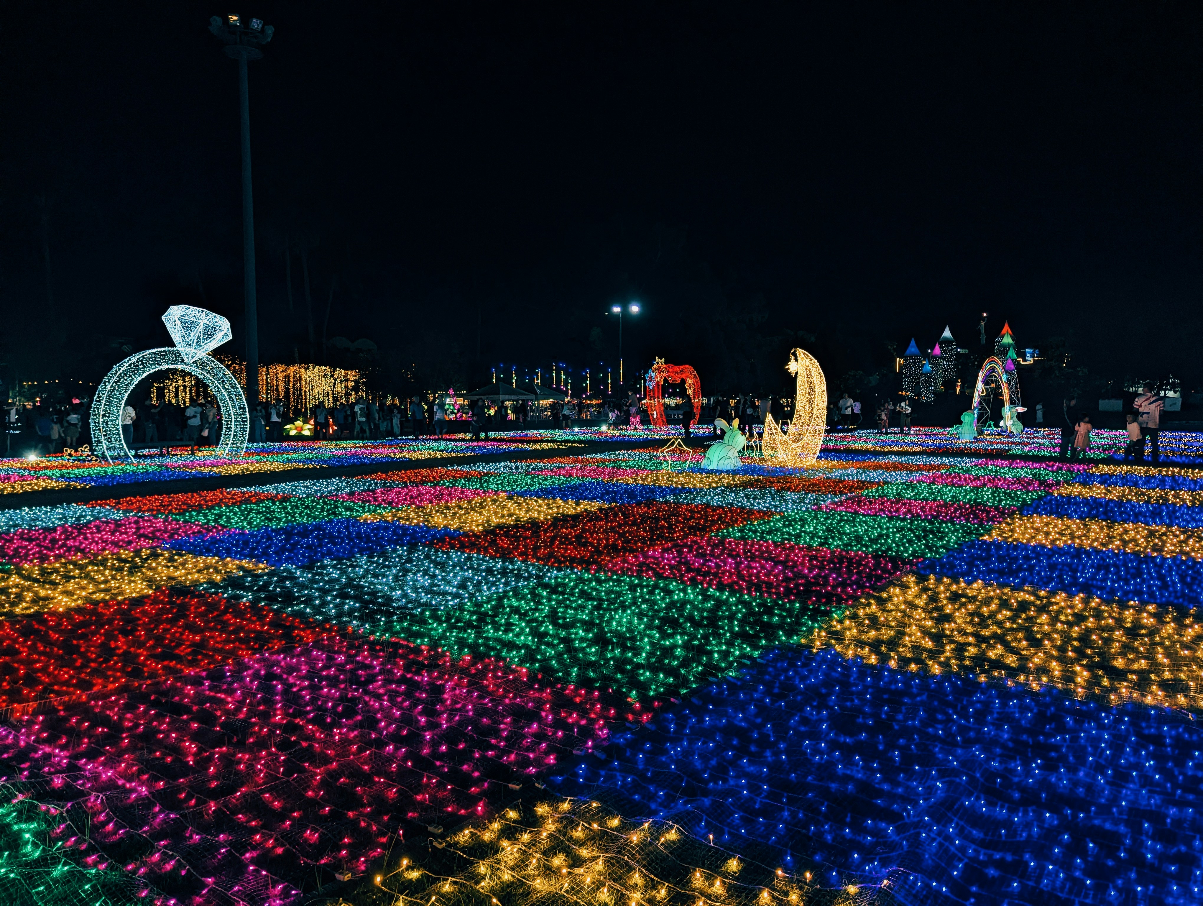 Colorful light display with ring and moon shapes at night