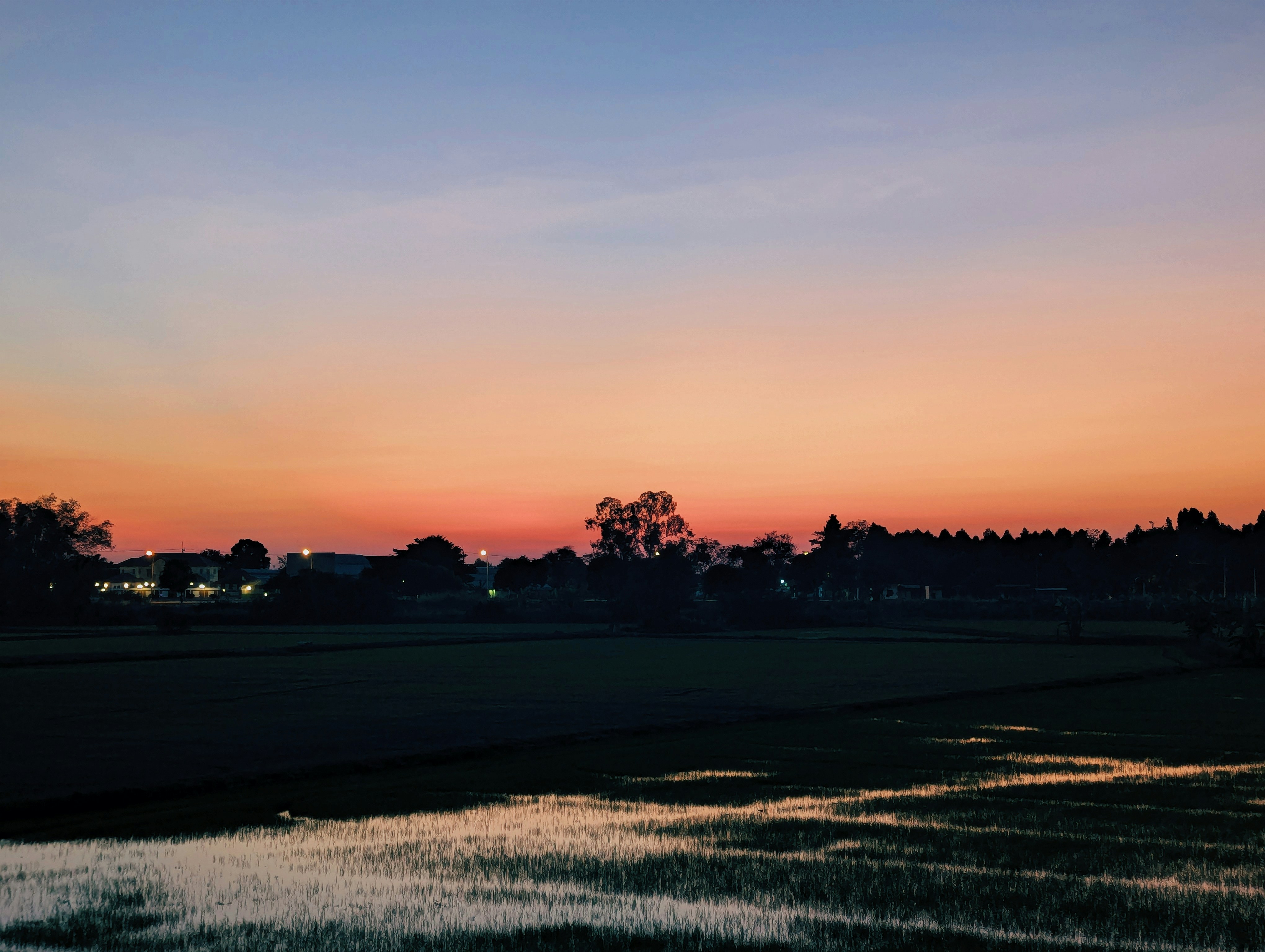 Sunset over a rural landscape with water reflections