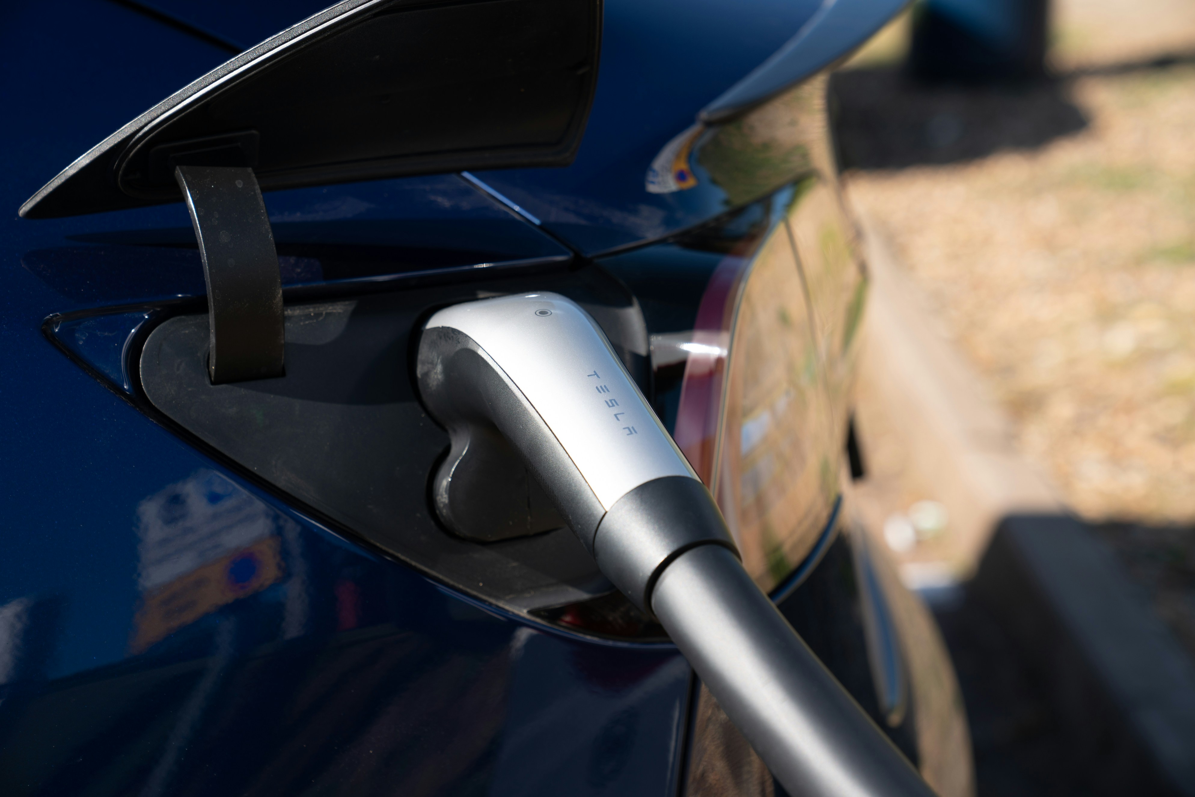 Electric car charging plug inserted into vehicle.
