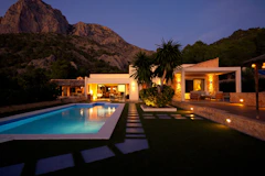 Modern house with pool at dusk near mountain