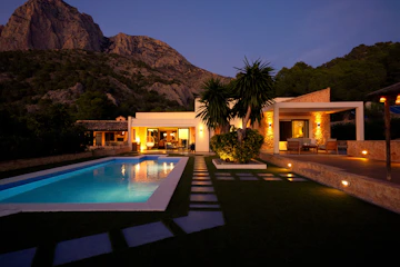 Modern house with pool at dusk near mountain