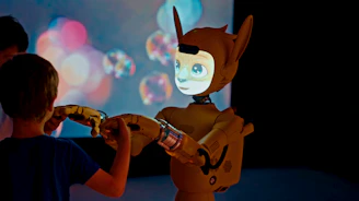 Child and robot interacting with projected bubbles